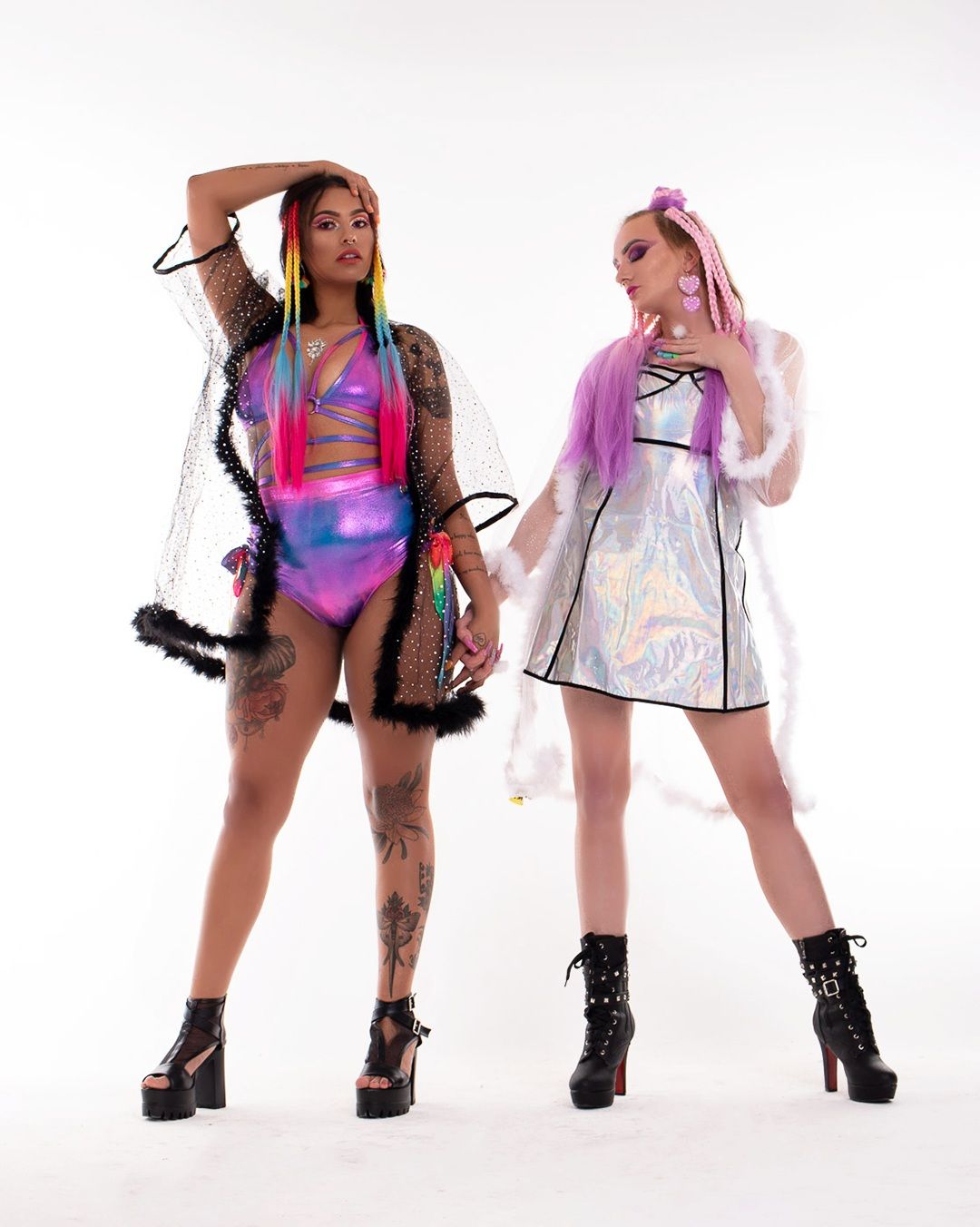 Fashion models pose in colorful holographic outfits and platform boots against white backdrop.