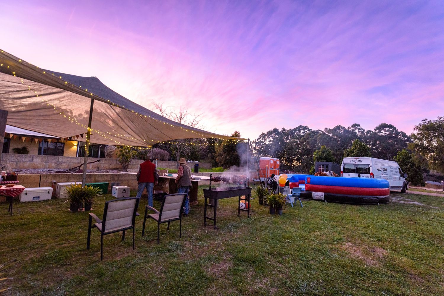 Outdoor venue at dusk with purple sky and string light decorations.