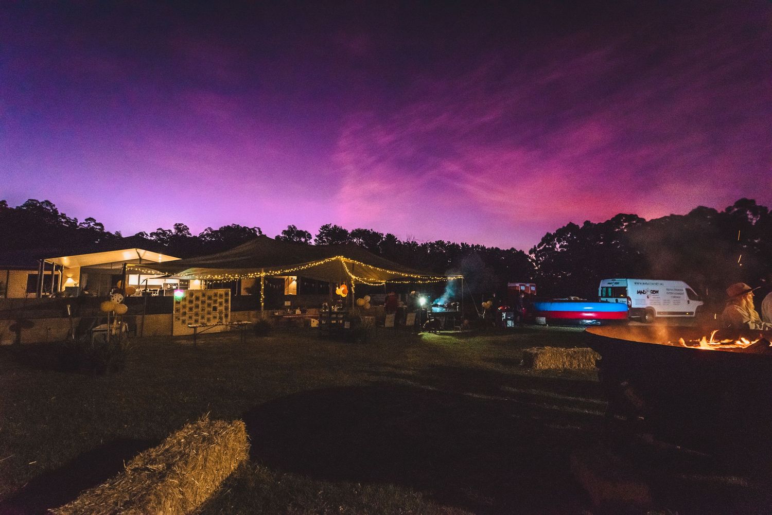 Atmospheric panorama of outdoor venue at night with deep purple sky.