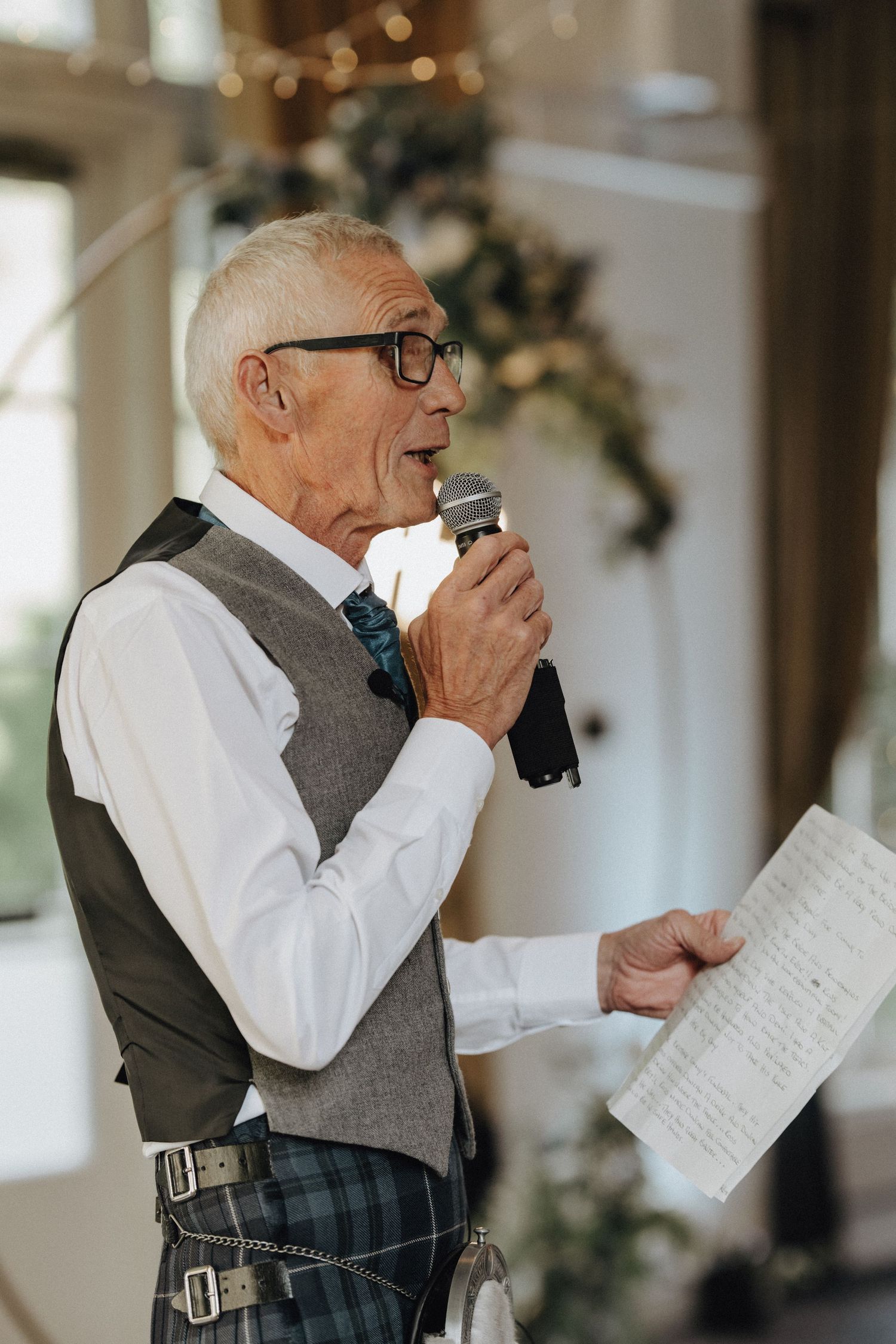Wedding speaker delivering an emotional speech while holding handwritten notes.