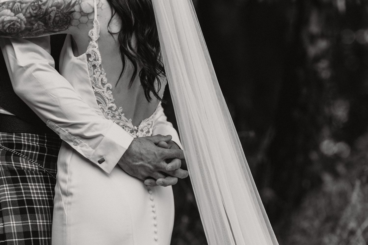 Close-up view of wedding dress details with delicate buttons and lace.