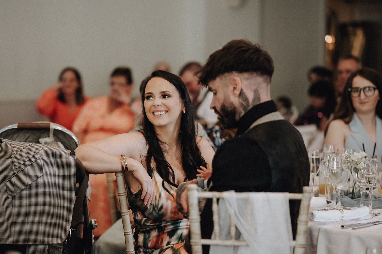 Wedding reception guests enjoying dinner and conversation at decorated tables.