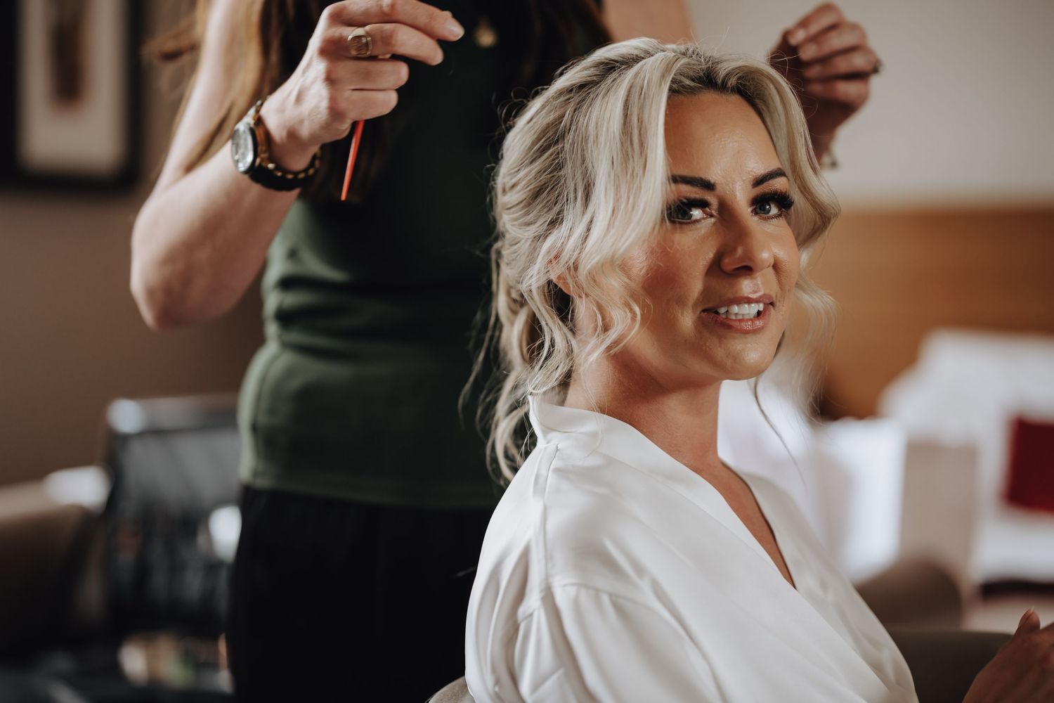 Getting ready on wedding morning with platinum blonde hair being styled while wearing a white robe.
