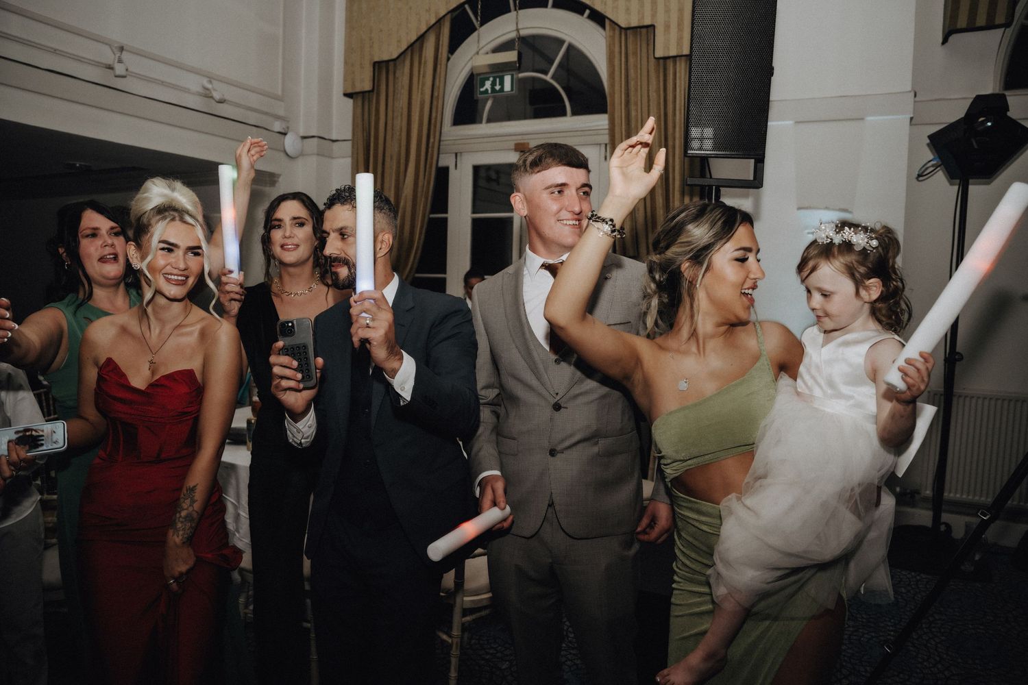 Wedding guests dancing and celebrating at a lively reception party.