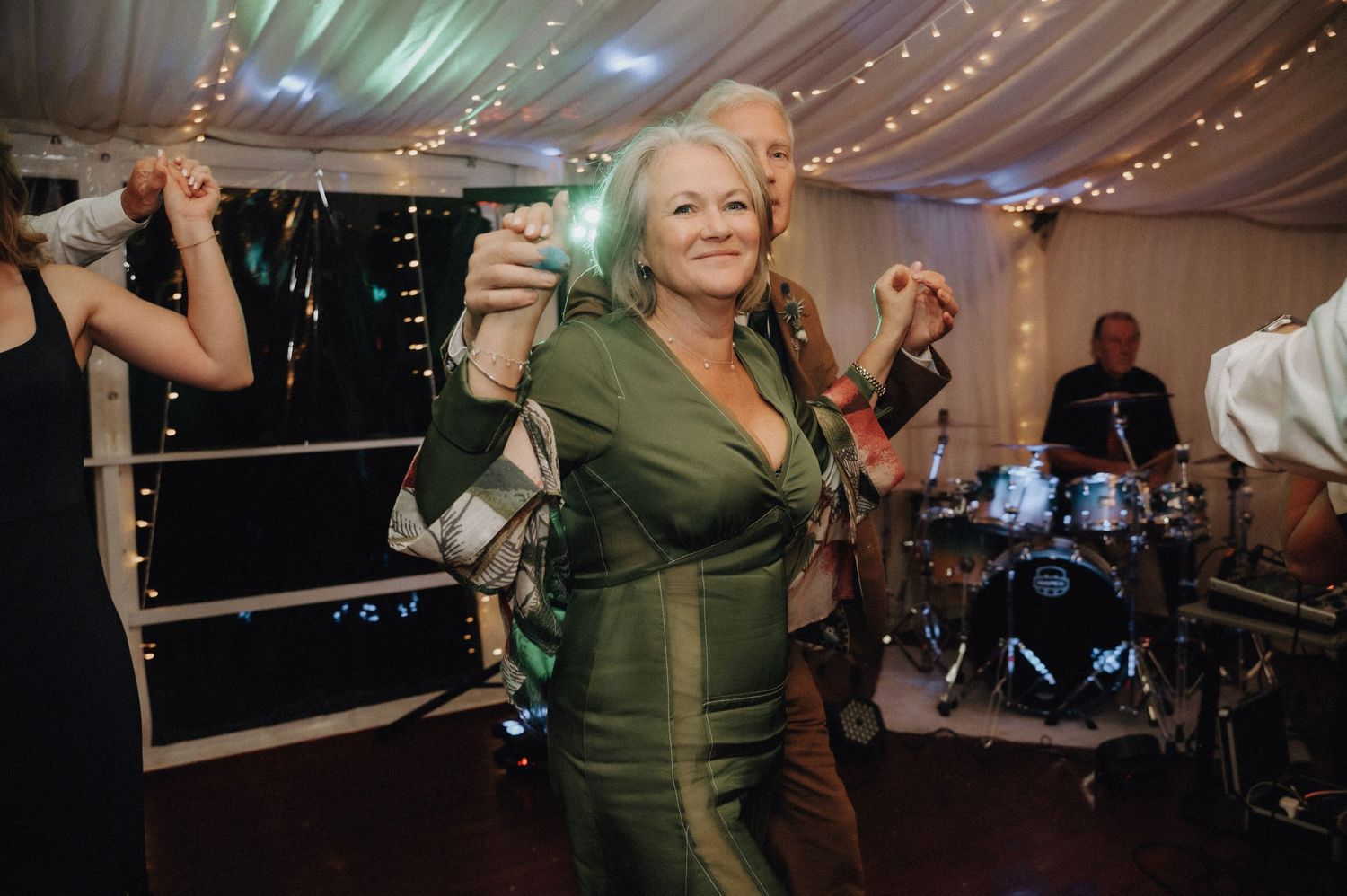 Guest in a green dress enjoying the wedding reception dance party.