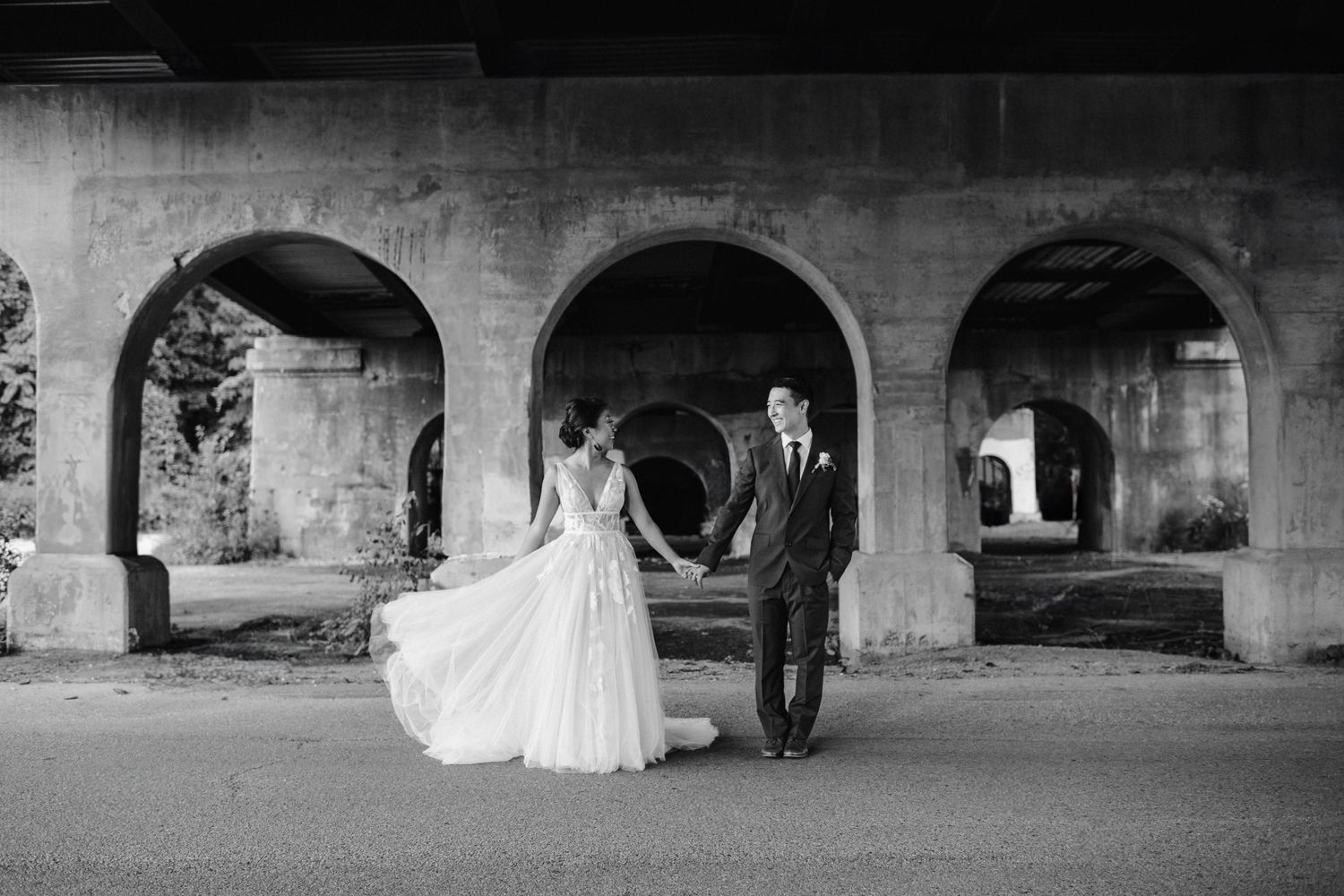 bride fans dress as couple stands under bride