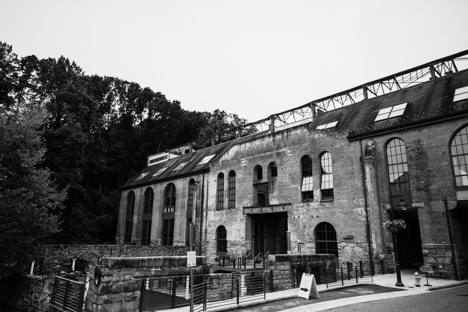 Black and white exterior view of a historic industrial building with brick facade.