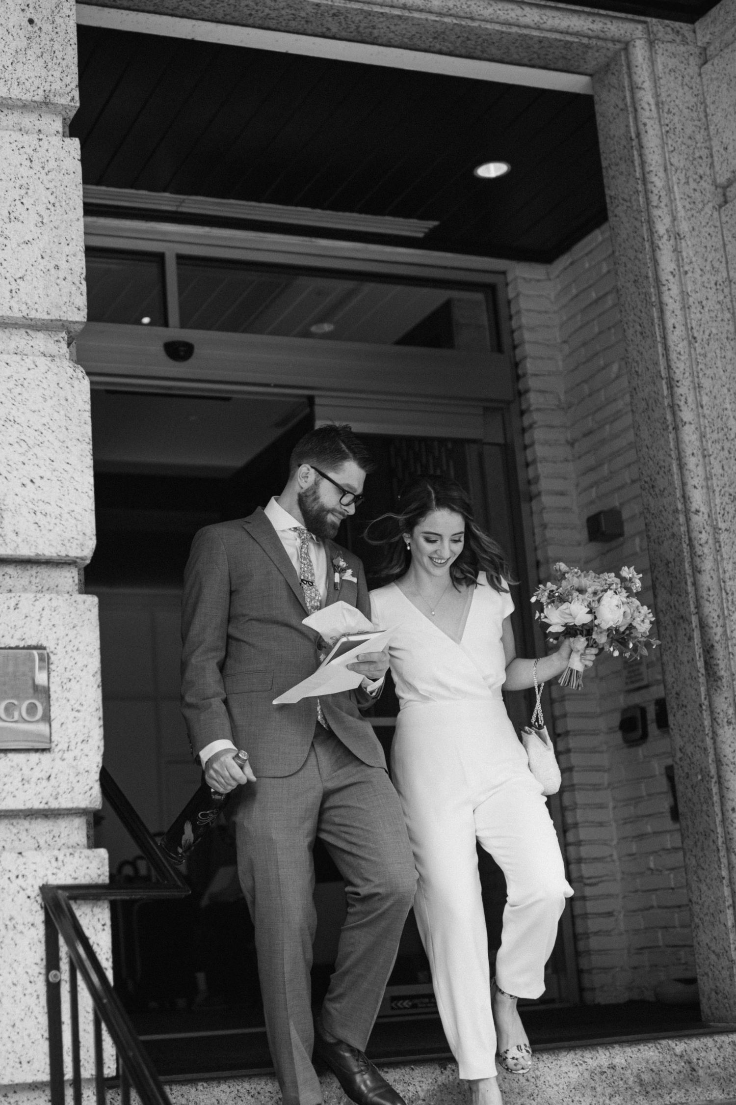 bride and groom walk out the front of the indigo hotel in baltimore