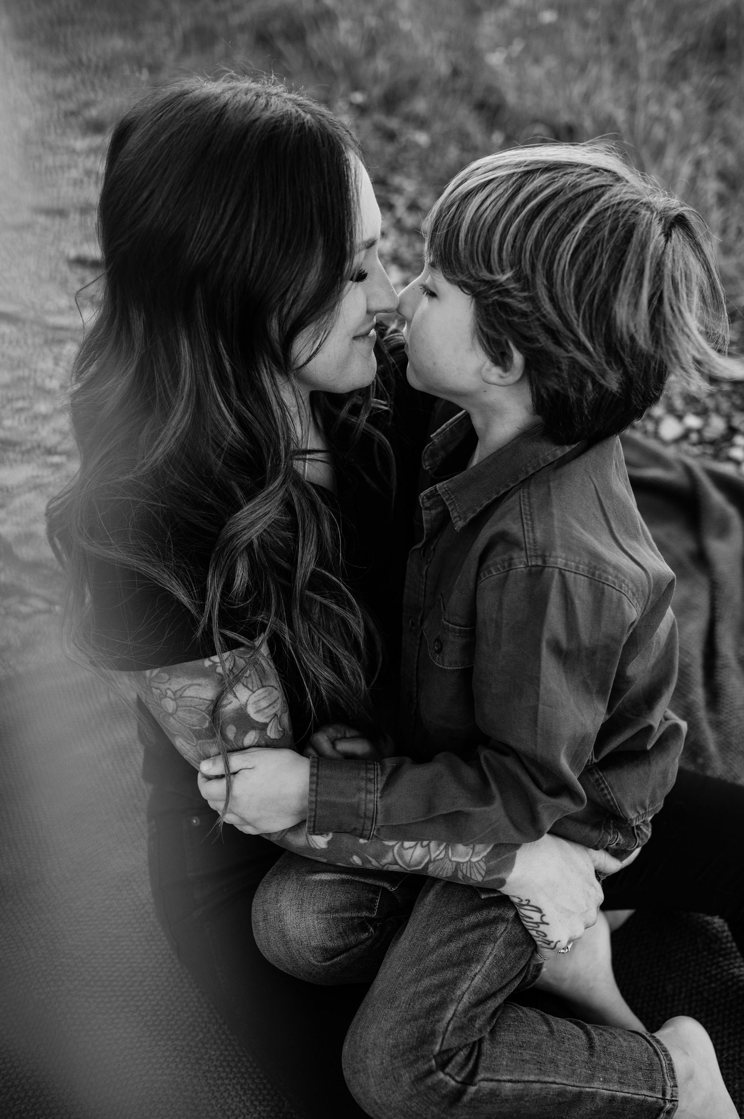 A tender black and white portrait capturing an intimate moment shared on a fall day outdoors.