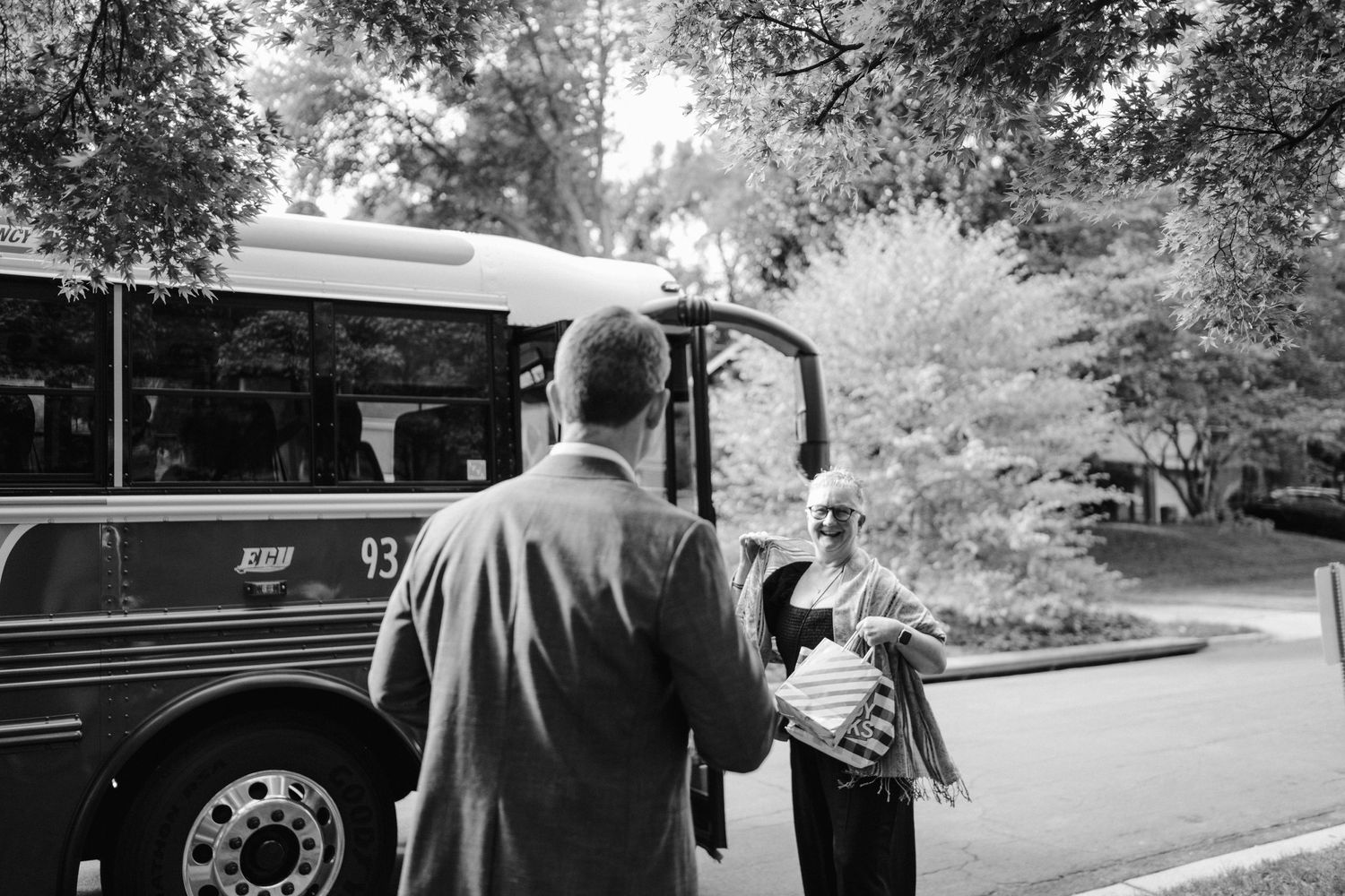 Transportation bus awaiting passengers outside in a black and white scene.