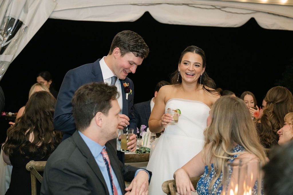 Wedding celebration under a tent with guests mingling and enjoying drinks at Strong Mansion on Sugarloaf Mountain