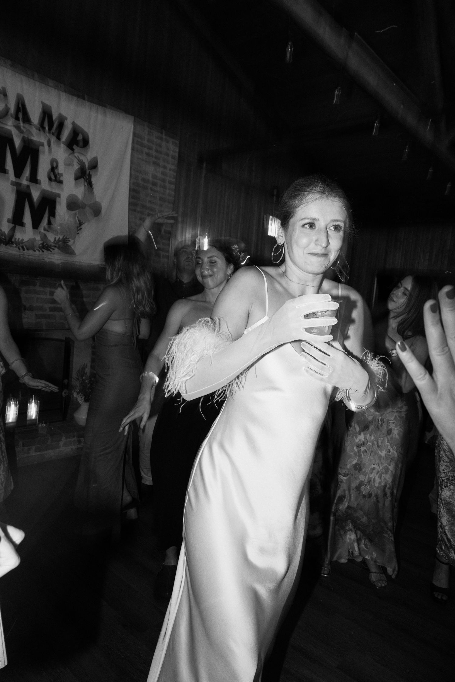 A bride in a sleek white gown dances at her wedding reception.