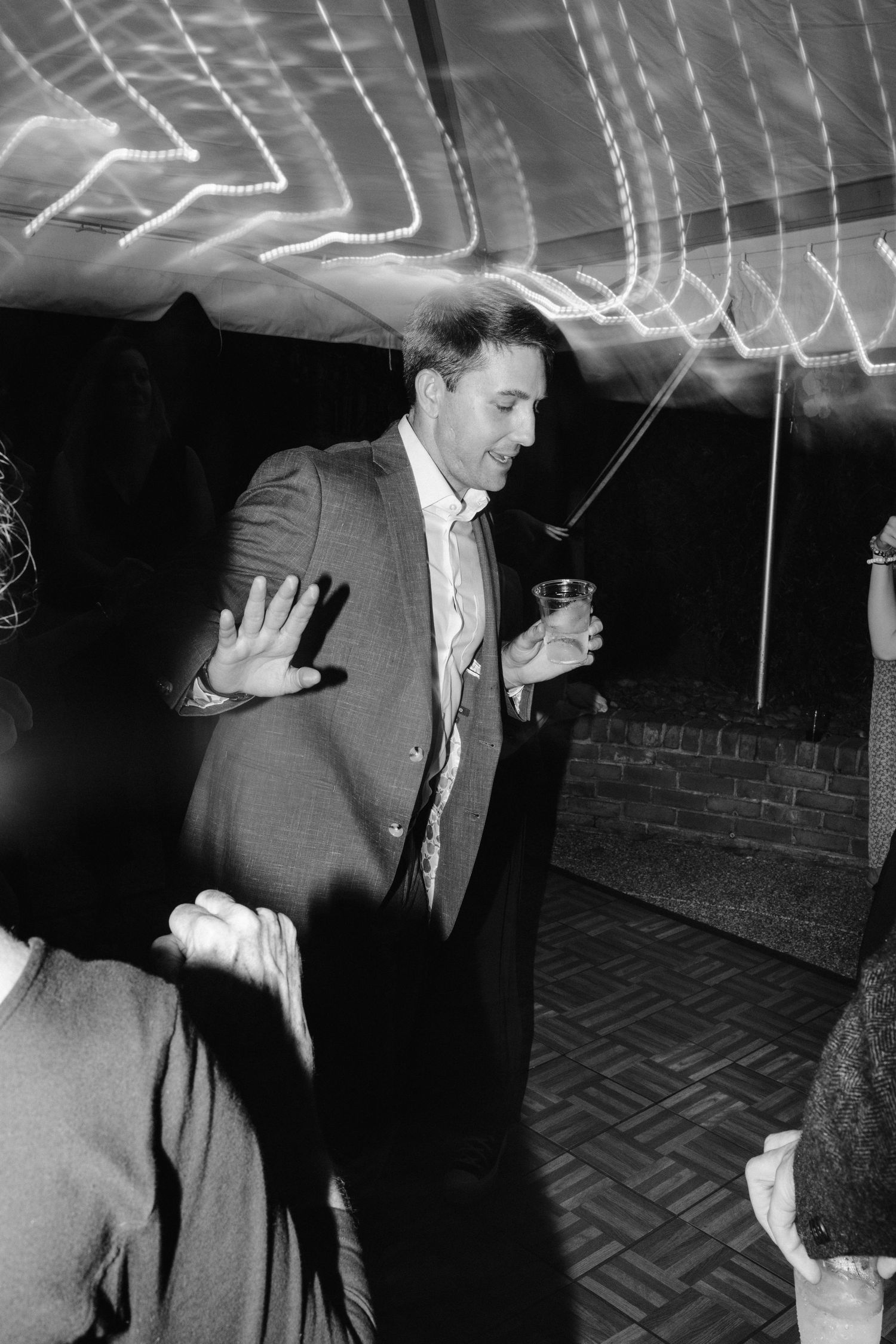 Black and white photo of dancing and celebrating at a lively party.