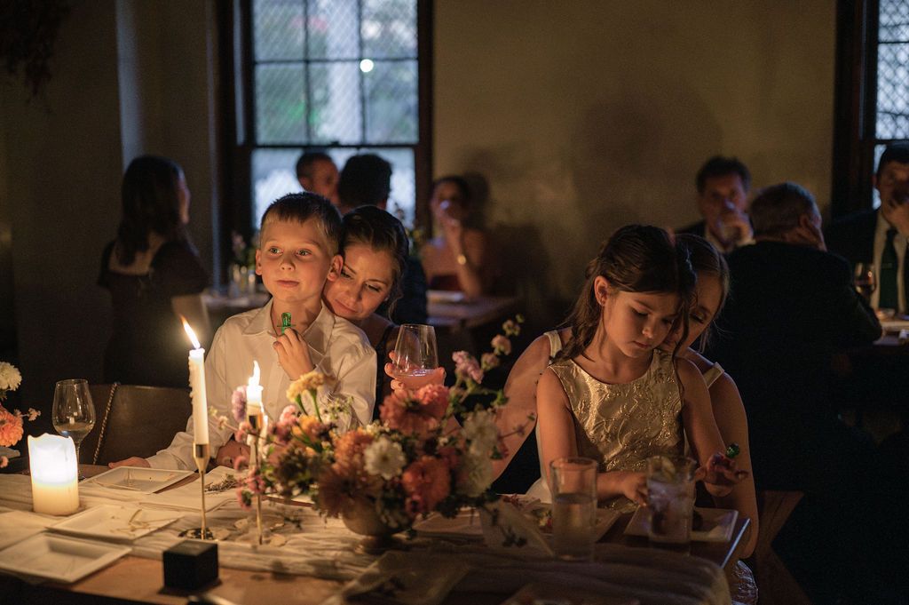 Elegant dinner party with candlelit table settings and floral arrangements.
