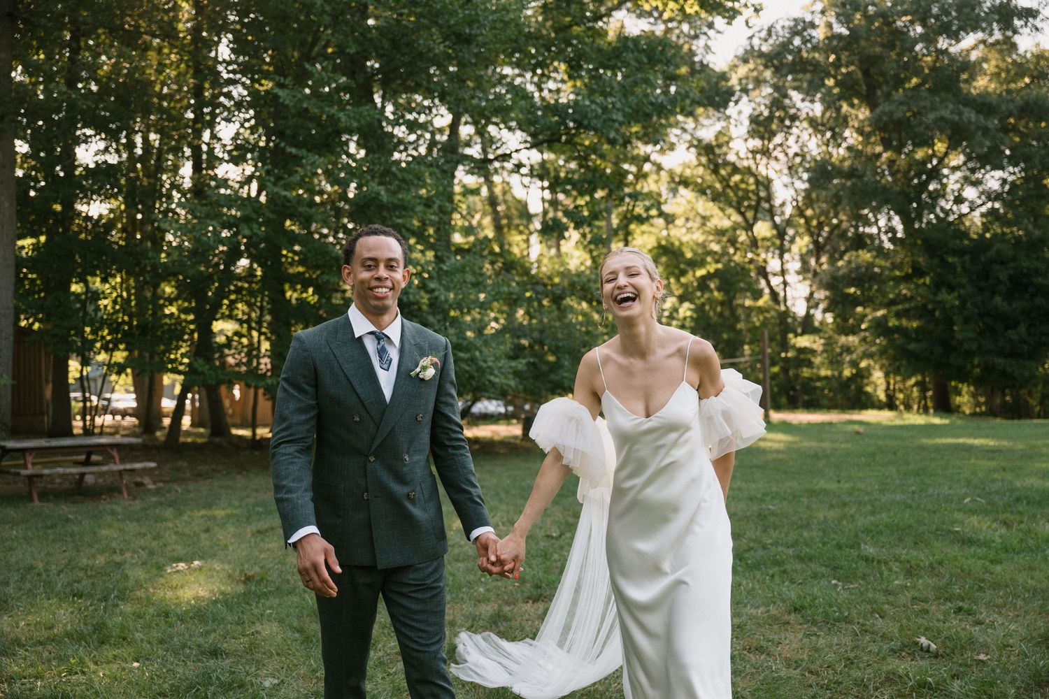 Wedding celebration in a sunlit forest clearing.