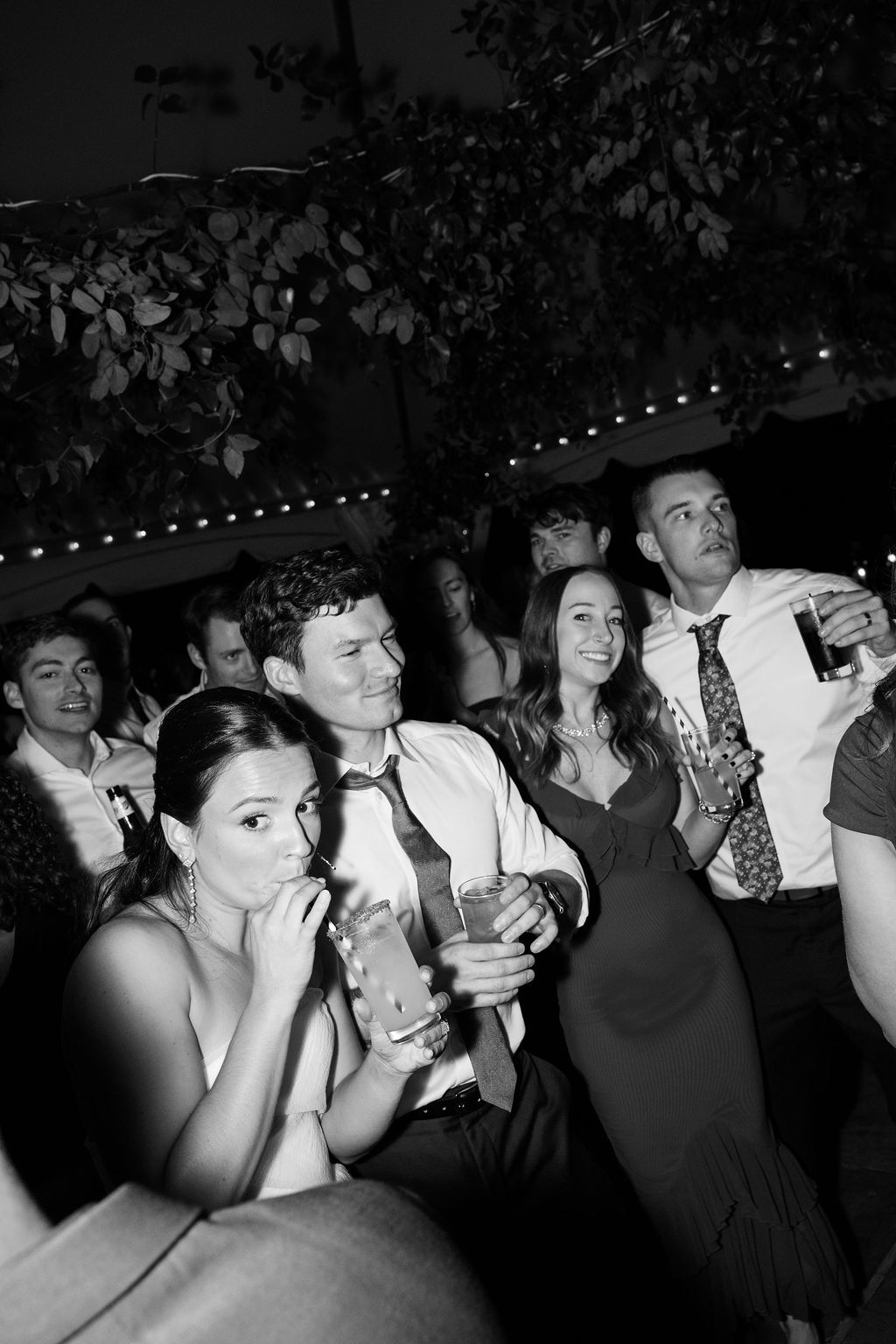 Bride and groom enjoy drinks and conversation at a dimly lit evening celebration at Strong Mansion on Sugarloaf Mountain