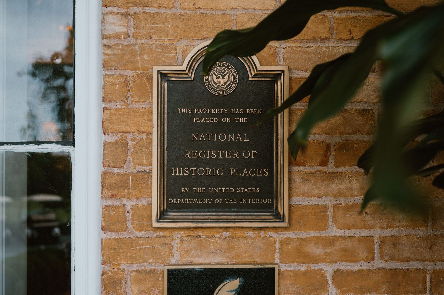 Historic bronze plaque mounted on brick wall indicating National Register of Historic Places designation.