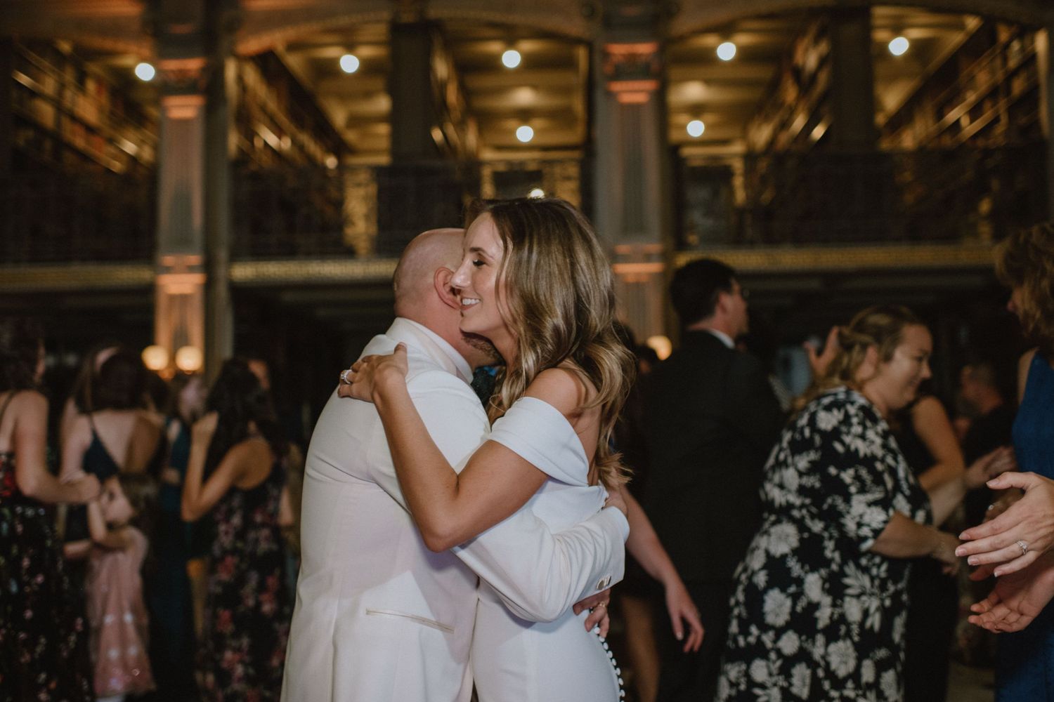 Couple shares an intimate slow dance together at an elegant indoor wedding reception.