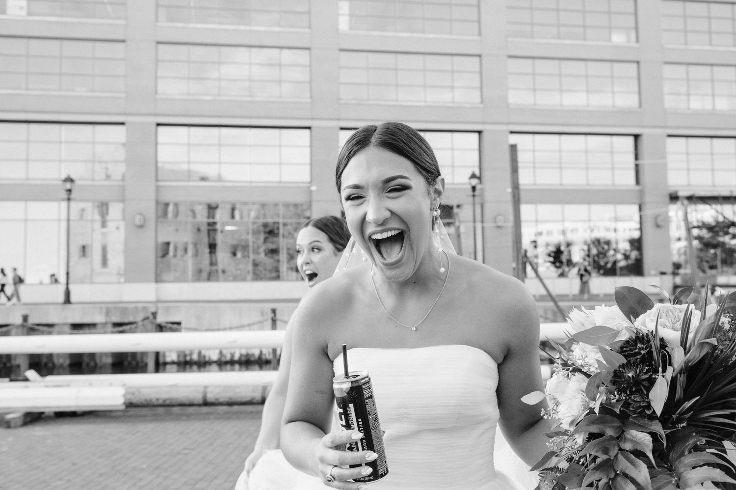 Black and white candid photo showing joyful reaction during outdoor wedding reception.