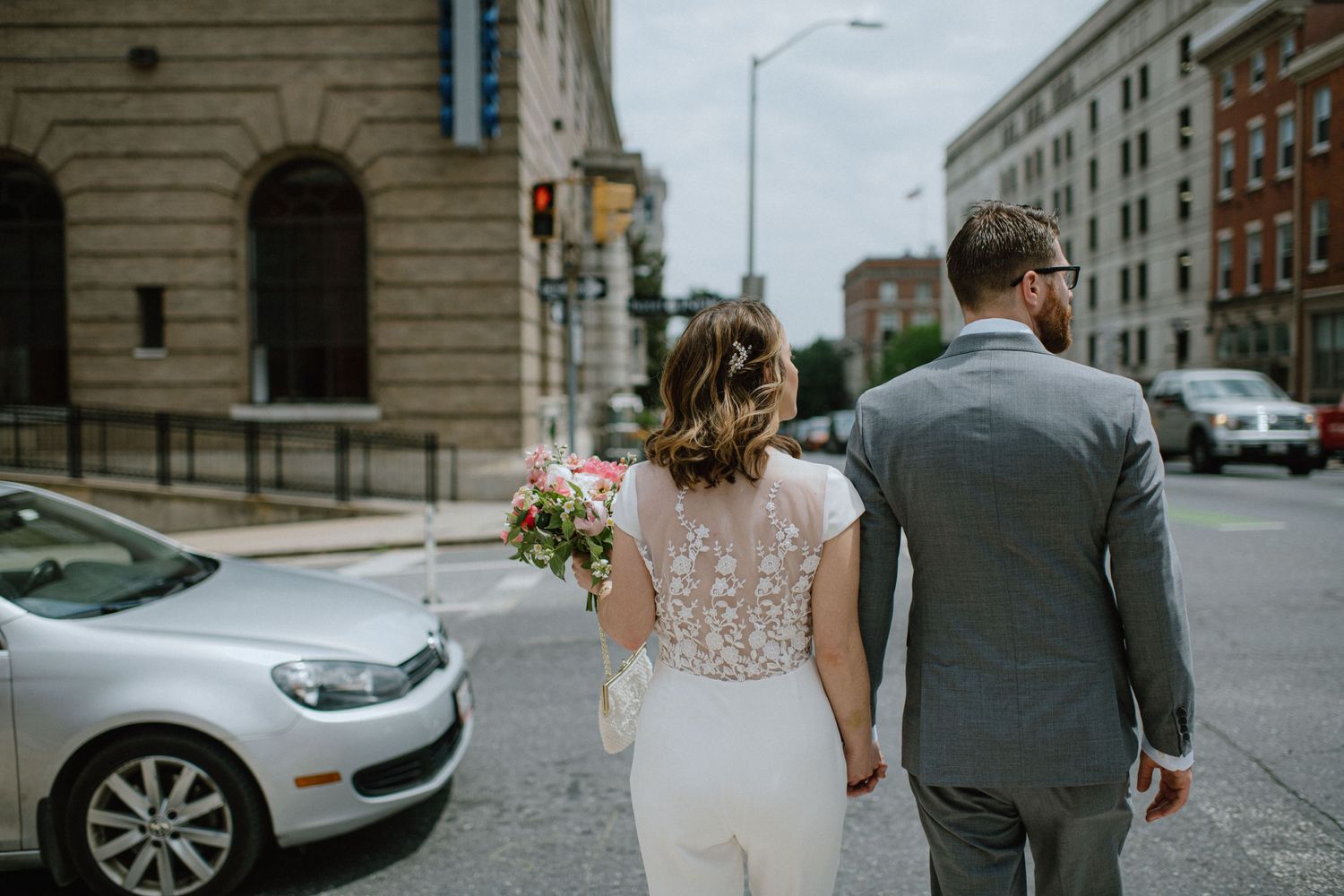 bride in bridal jumper waiting to cross the street