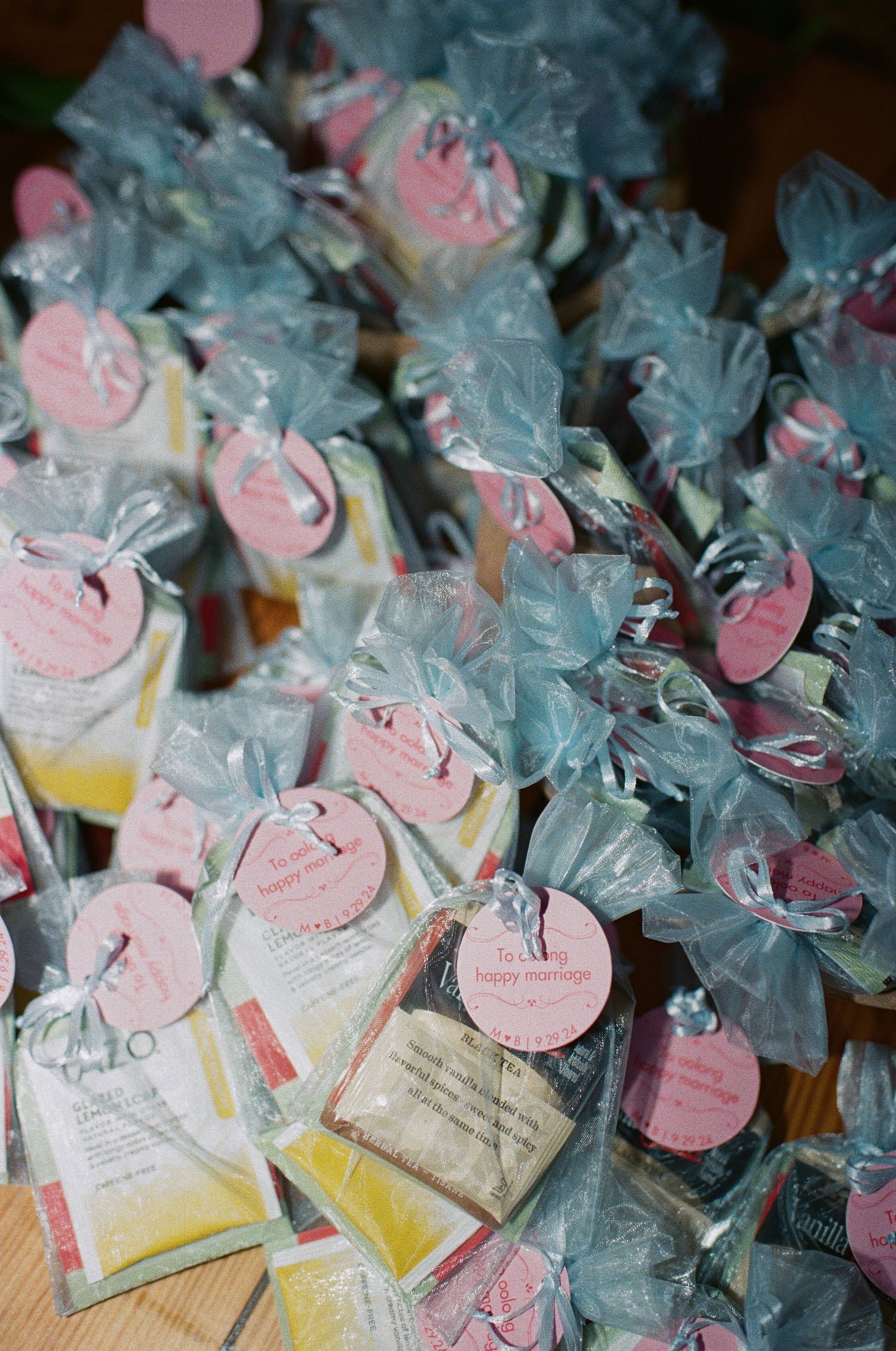Small wedding favors wrapped in tulle with pink tags attached.