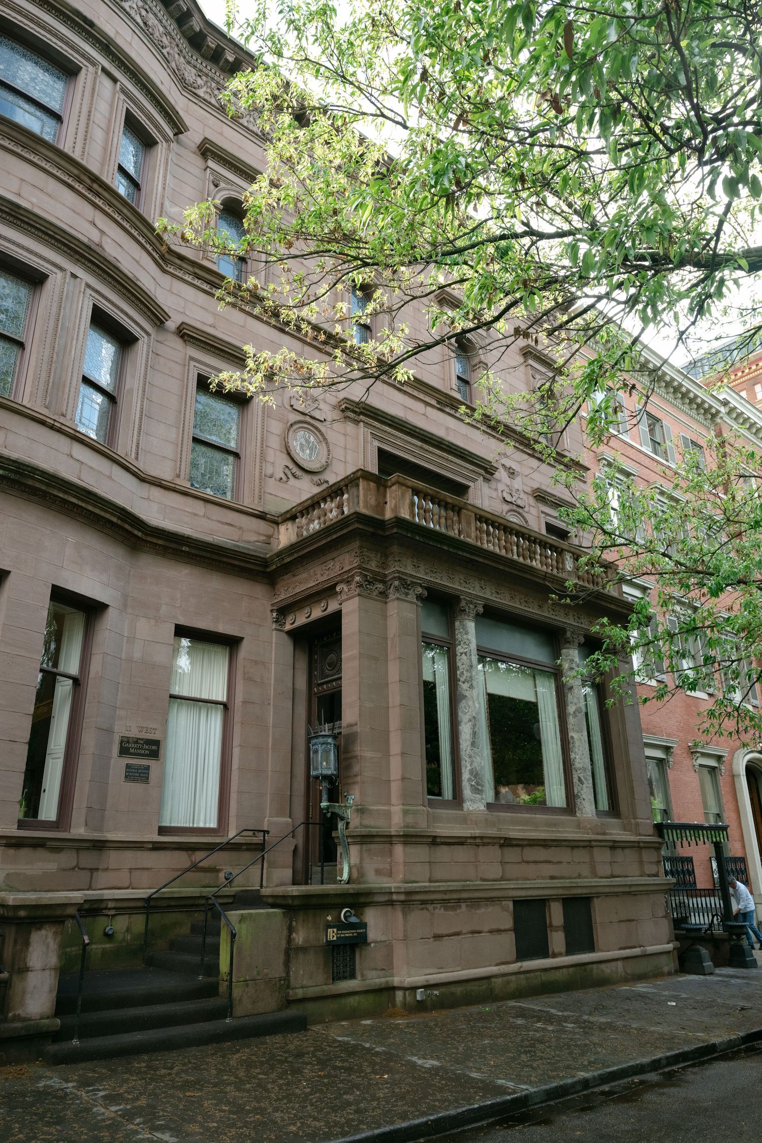 Historic brownstone building with ornate architectural details and bay windows on a tree-lined street at a Baltimore engineers club wedding