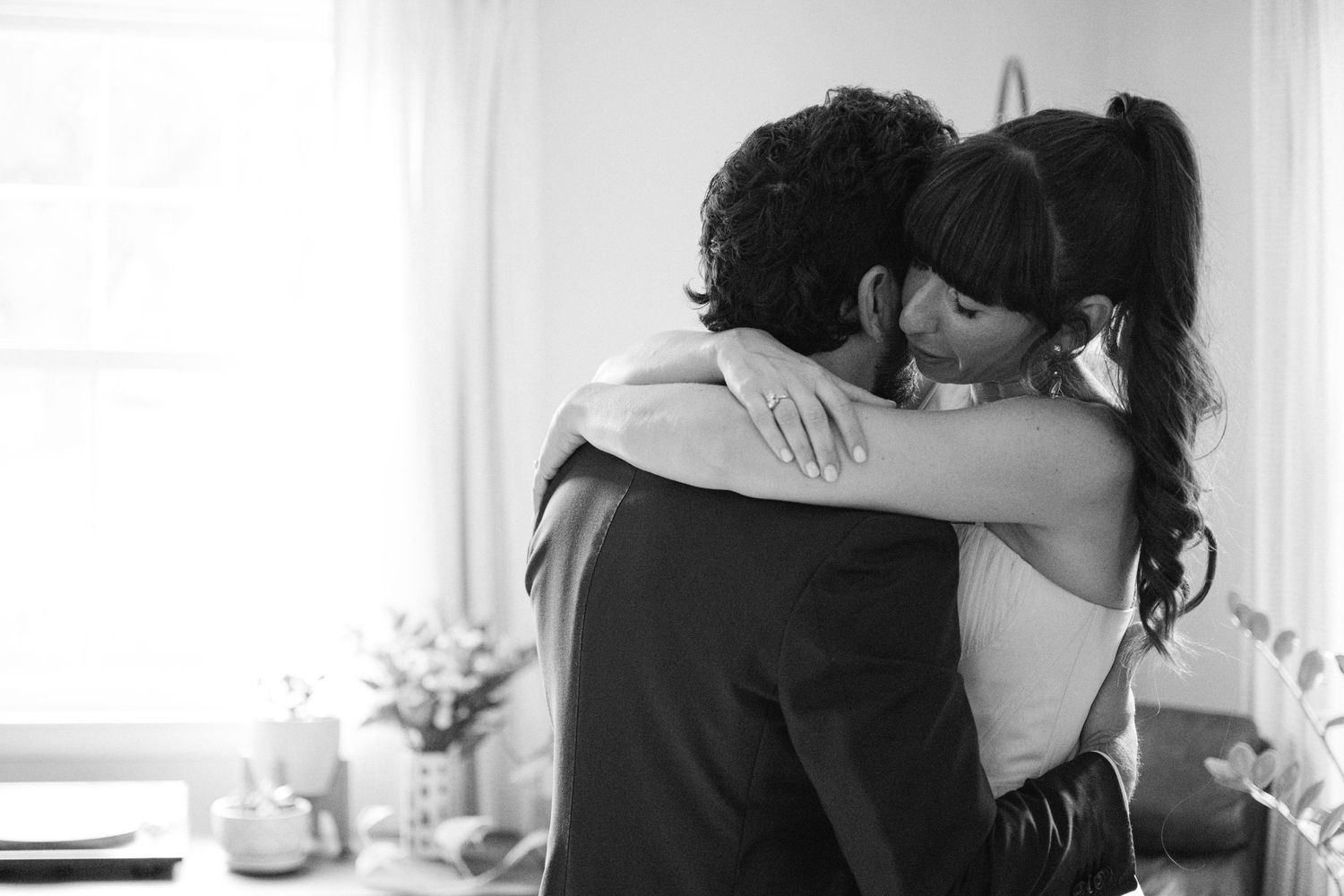 Intimate black and white photo of newlyweds embracing during their special moment.