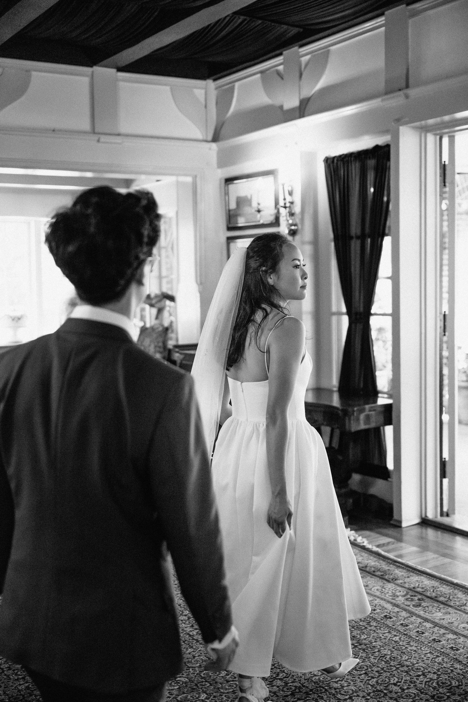 Black and white wedding sequence showing guests walking through an elegant indoor venue.