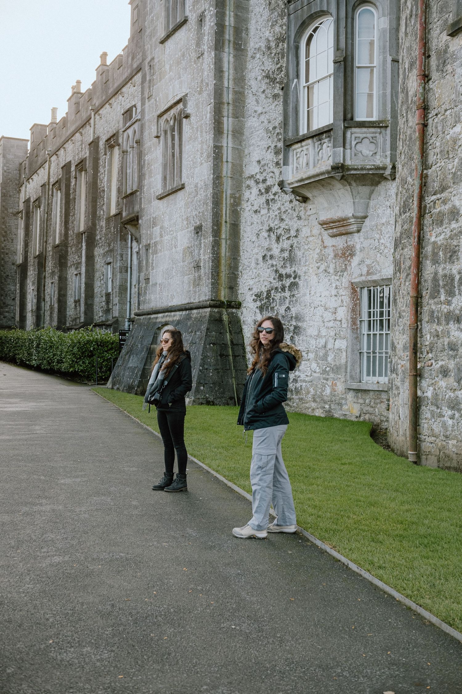 Historic stone castle exterior with visitors walking along the pathway.