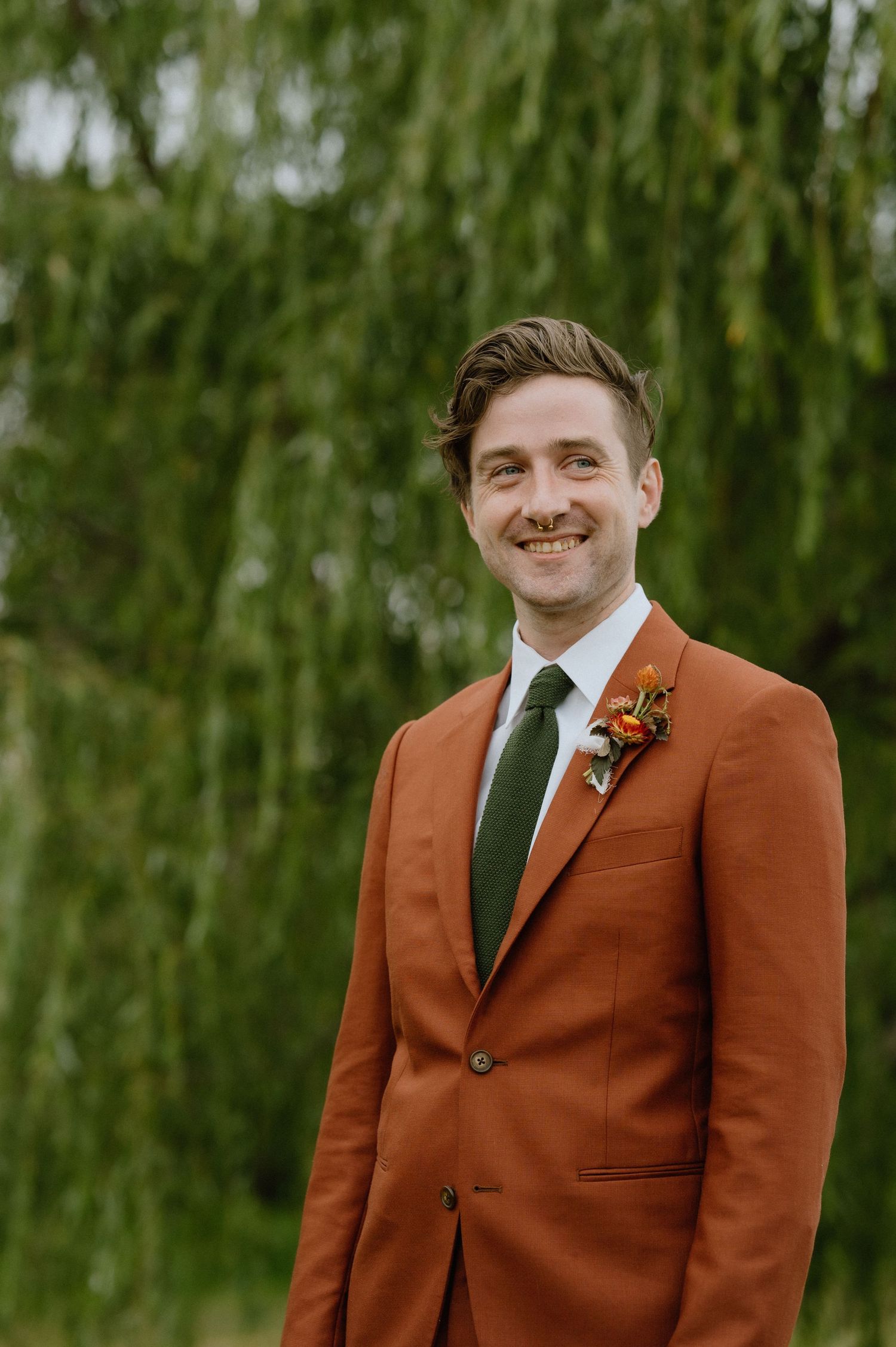 portrait of groom standing at altar in rust orange suit non-traditional boho wedding maryland photographer