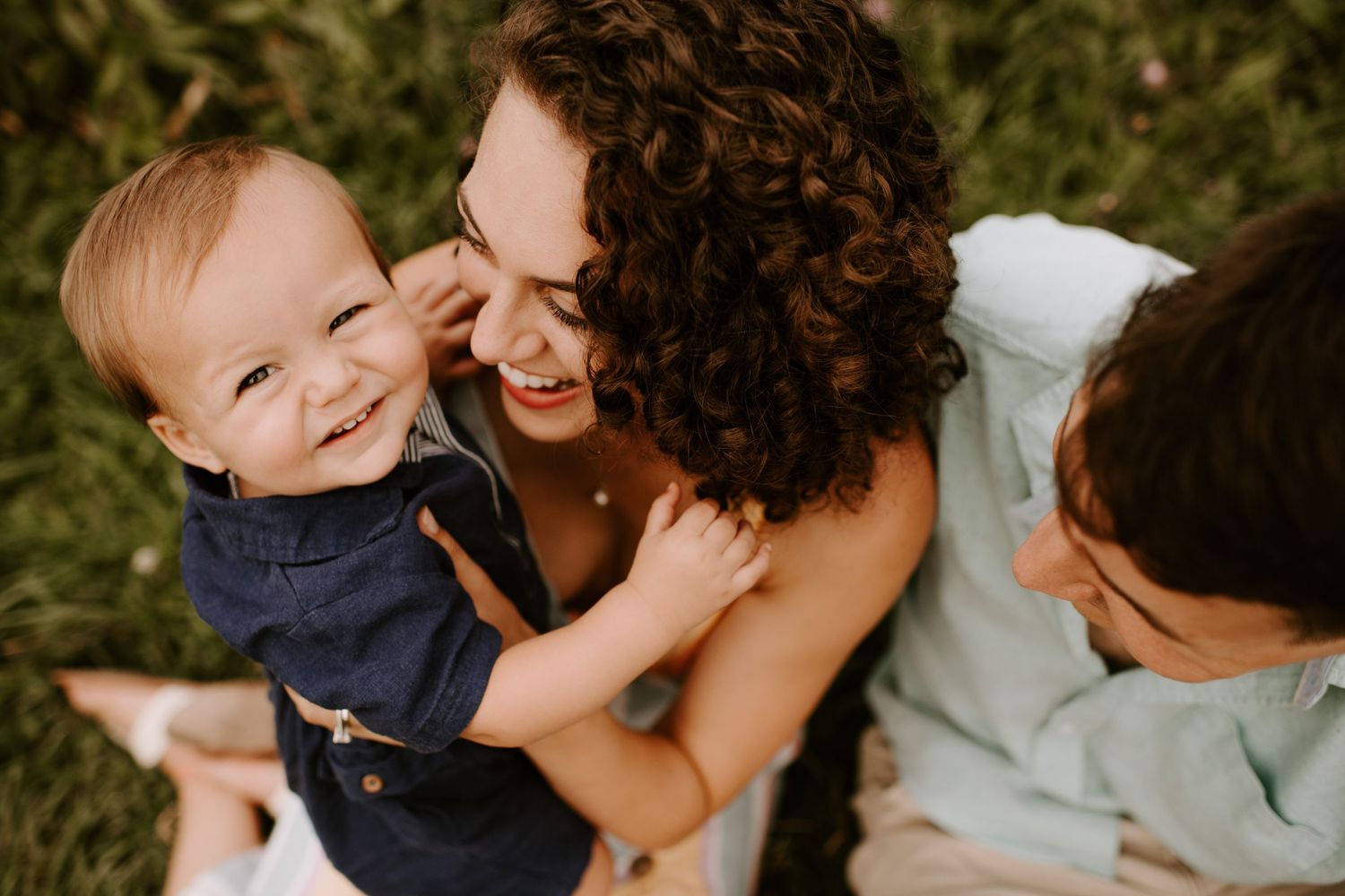 Candid family photo capturing laughter and joy in warm sunlight.