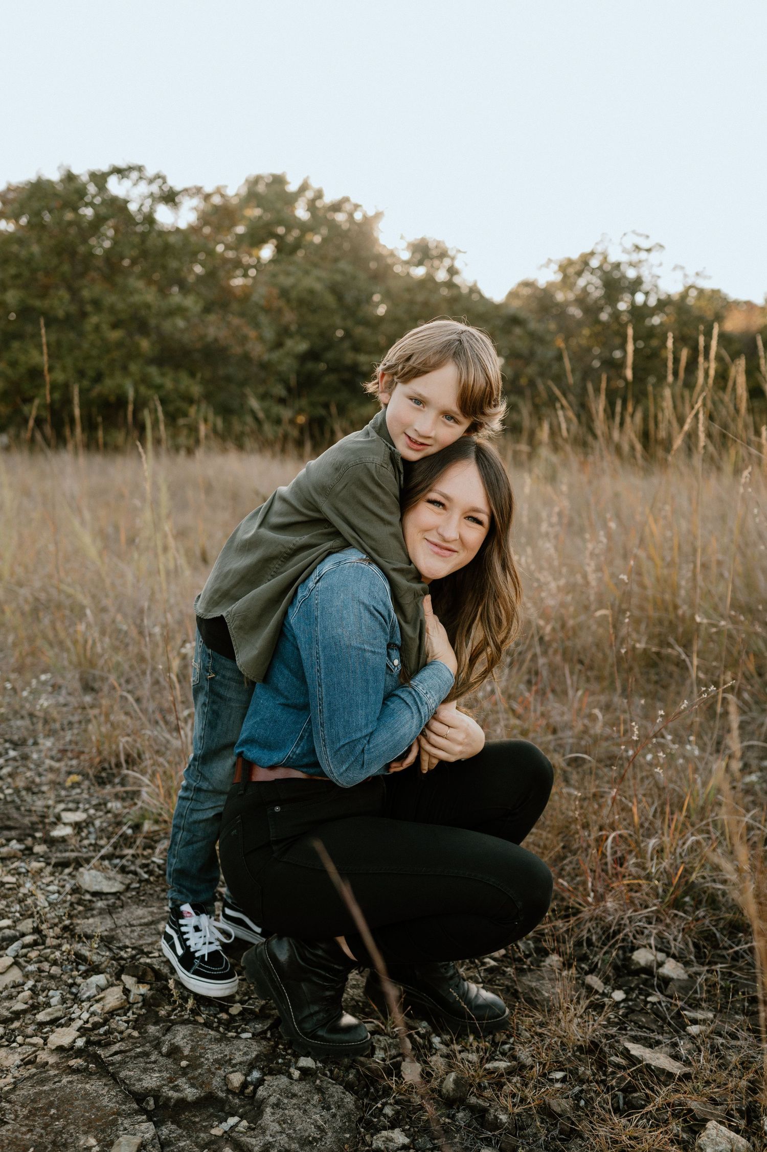 Playful outdoor portrait session in golden field with tall grass.