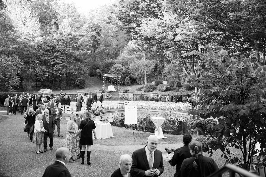 Black and white panoramic view of an outdoor wedding ceremony with guests seated on the lawn at Strong Mansion on Sugarloaf Mountain