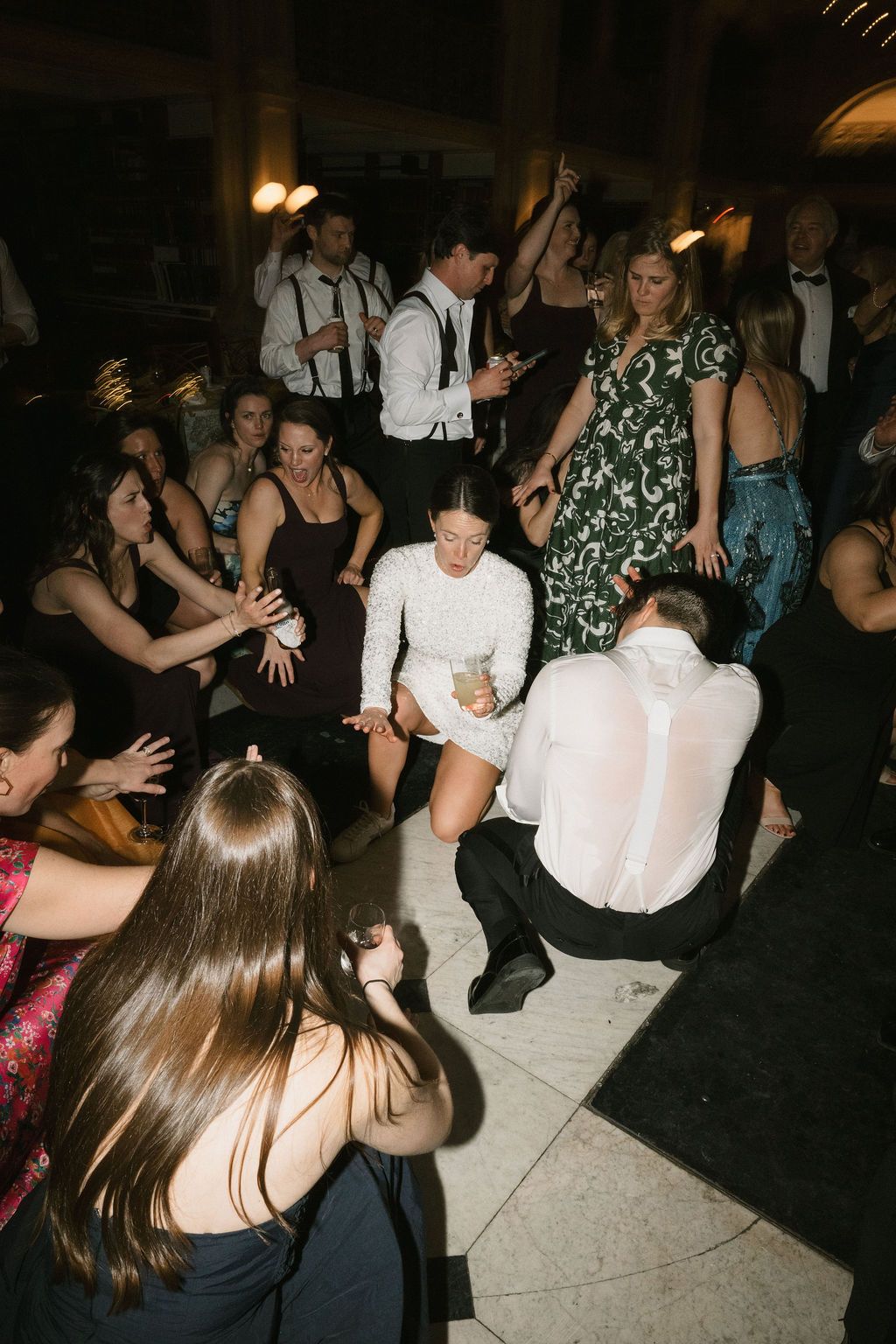 Wedding guests dancing energetically on a crowded dance floor at an evening reception at George Peabody Library Wedding in Baltimore