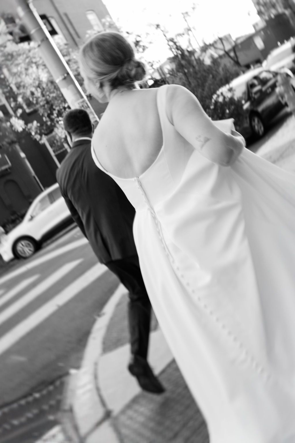Black and white wedding photos showing couple walking on urban street.