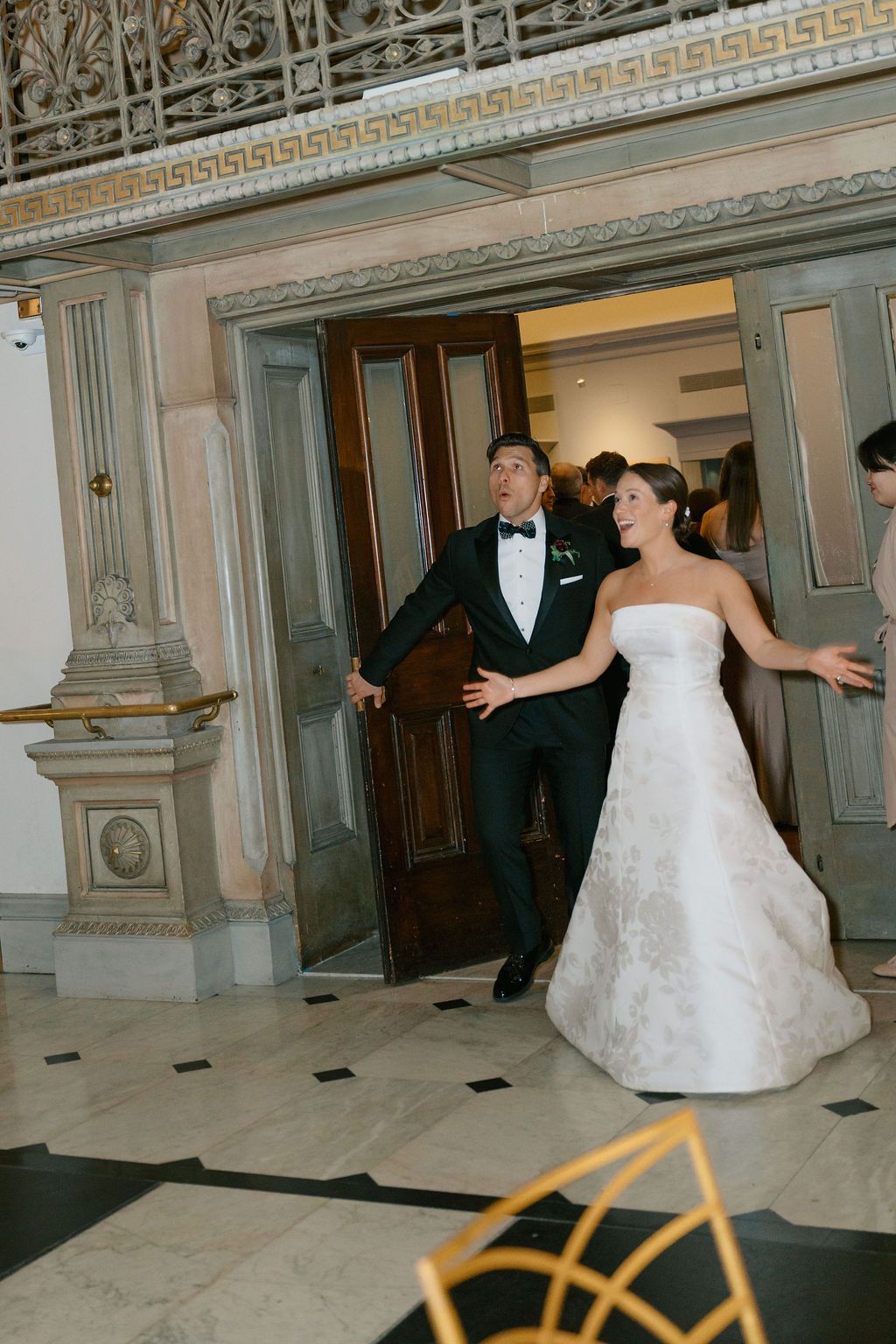 Grand entrance in an ornate historic building with decorative moldings and marble floors.
