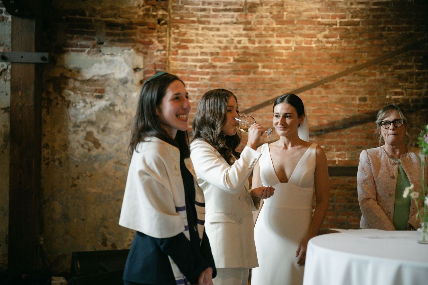 Wedding celebration in rustic brick venue with guests mingling and dancing.