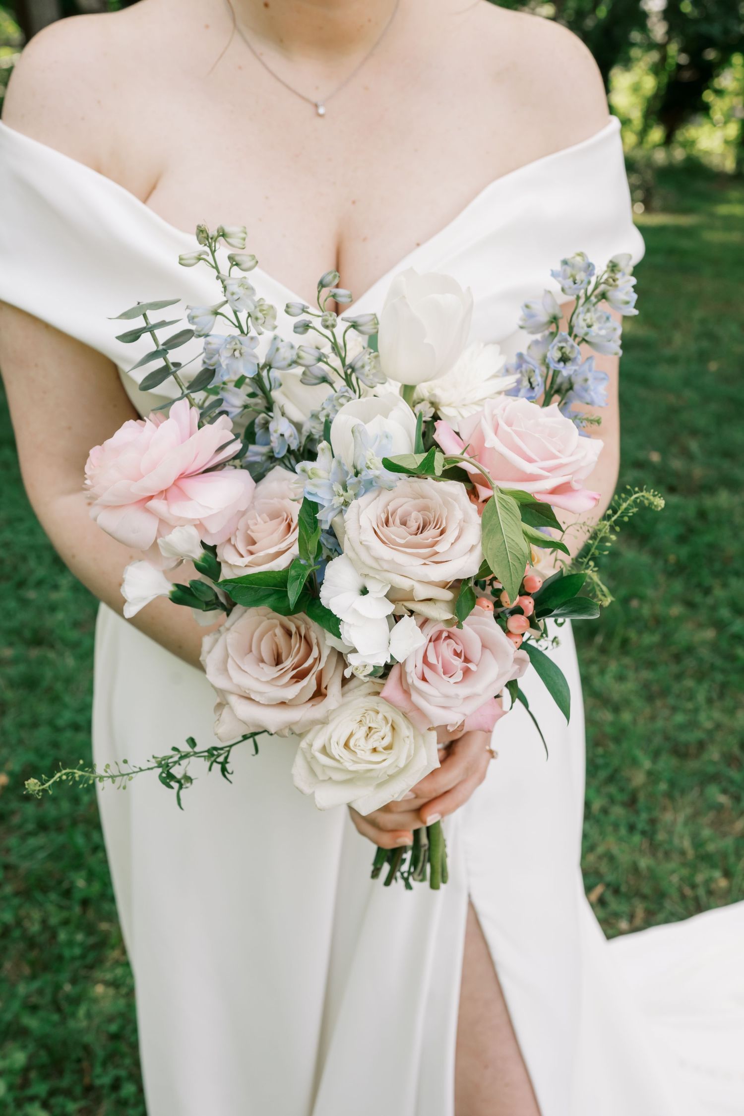 Elegant bridal bouquet featuring pink and white roses with delicate greenery.