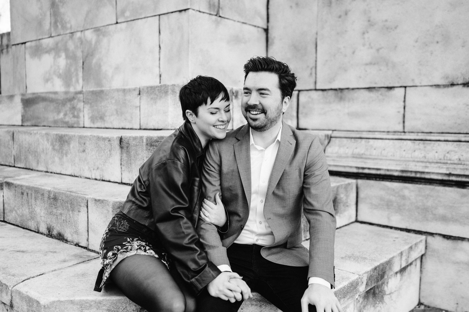 Casual couple sharing intimate moment while sitting on stone steps.