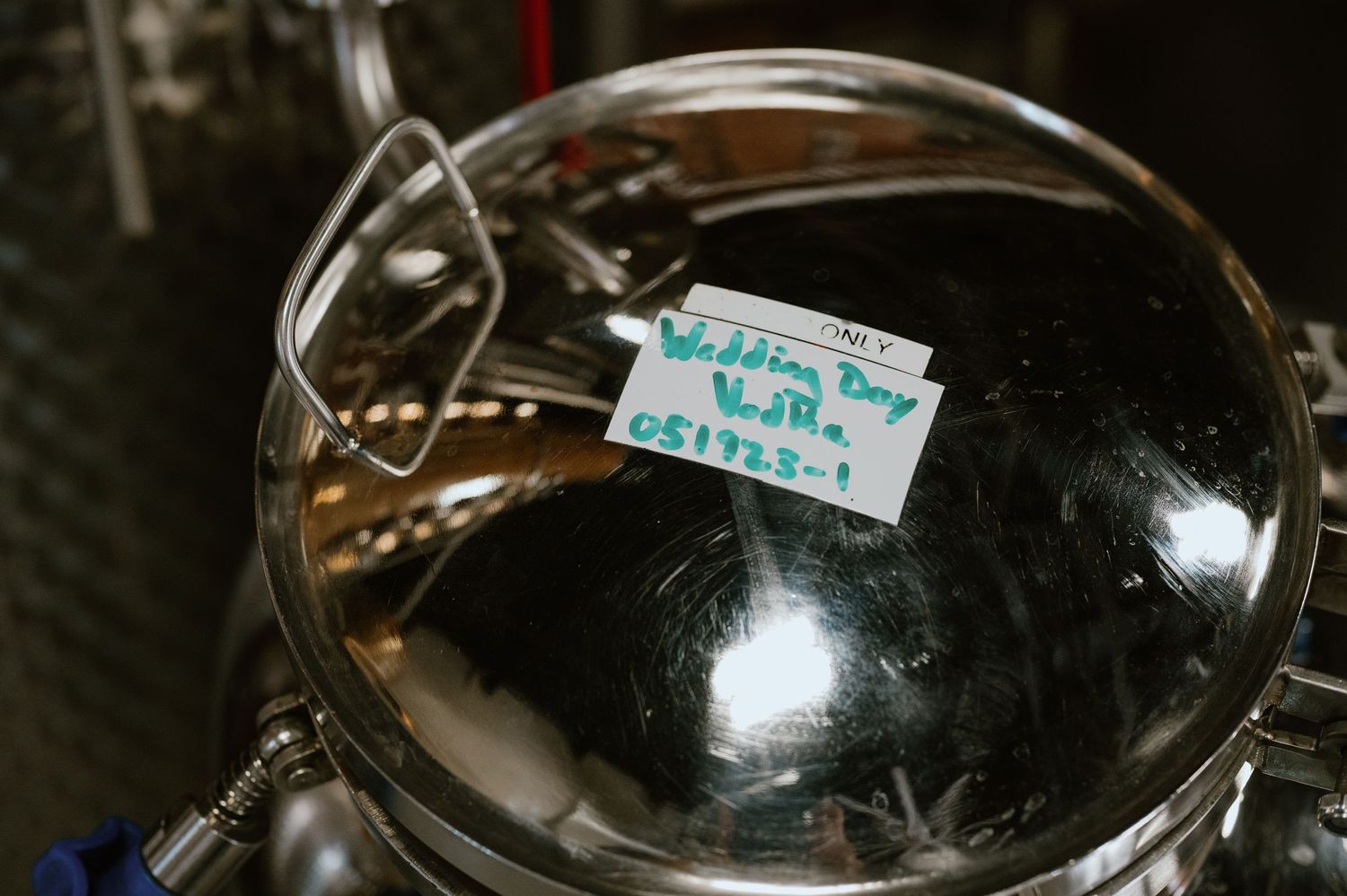 Close-up shot of a stainless steel brewing vessel with a small label visible on top.