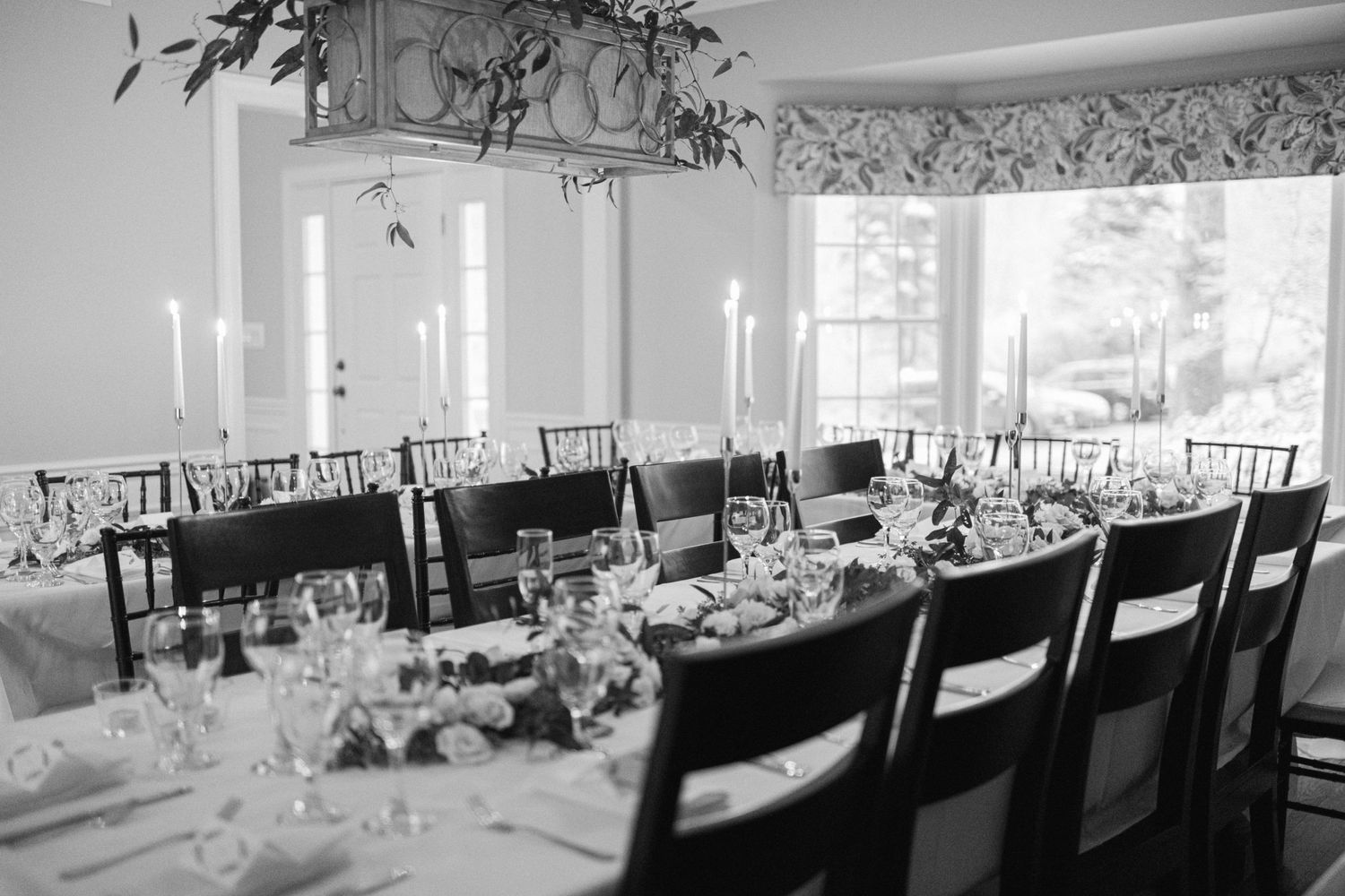 An elegant black and white reception table setting with tall candlesticks and place settings.