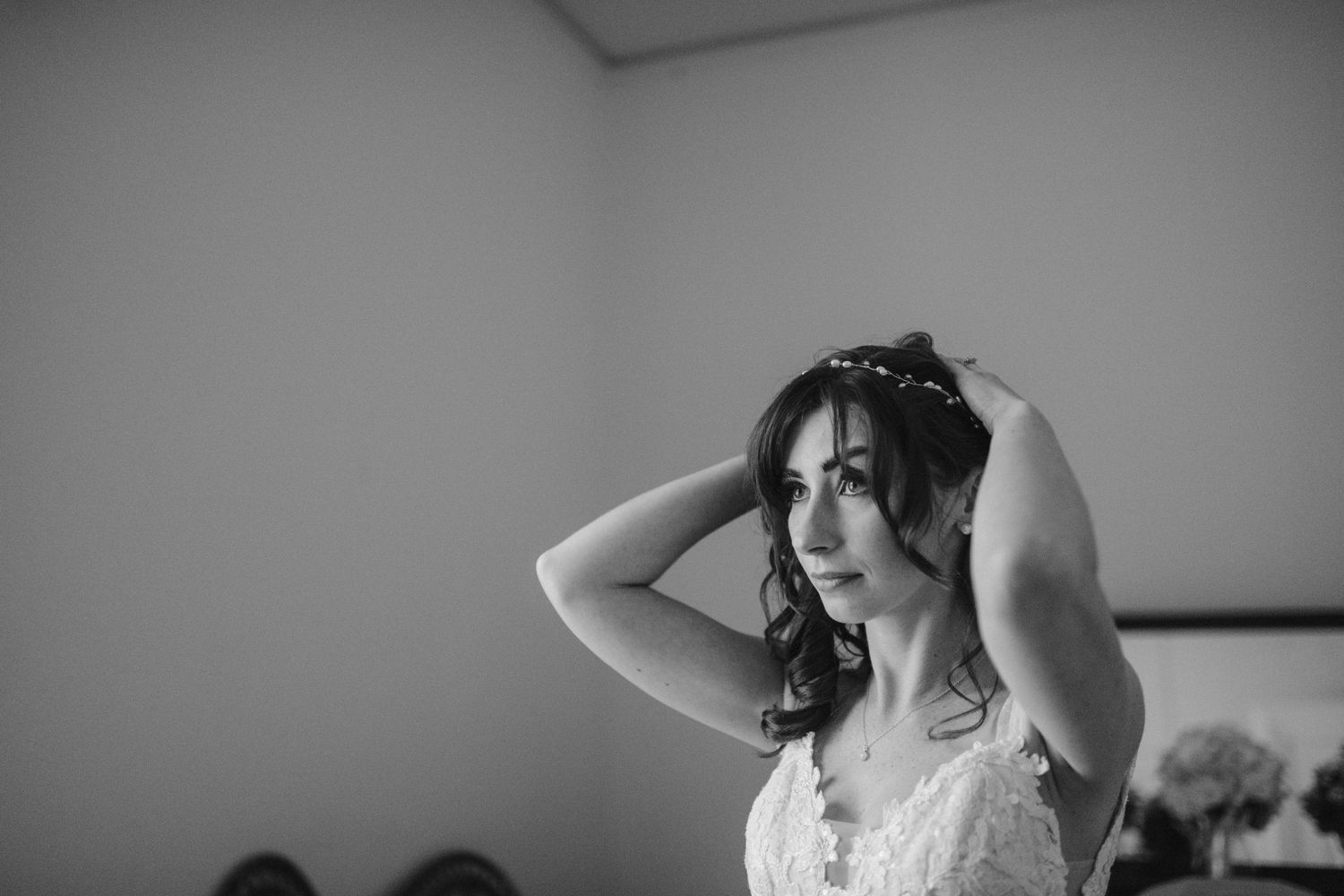 bride fixing her hair at strong mansion in frederick maryland wedding photographer