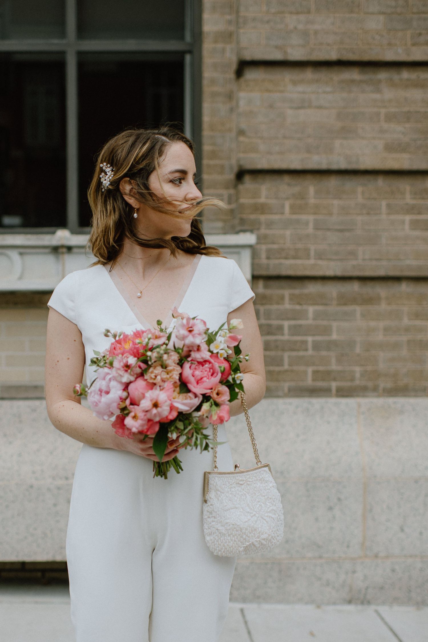 bride waits to cross street wind blows her hair