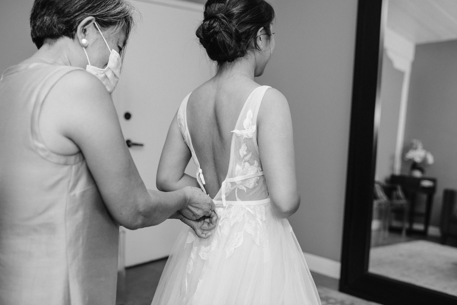 mother zips bride into dress