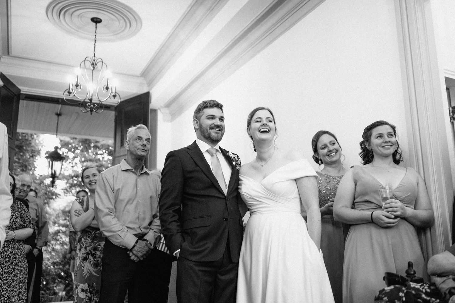 Black and white photo of a joyful celebration moment at an elegant wedding reception.