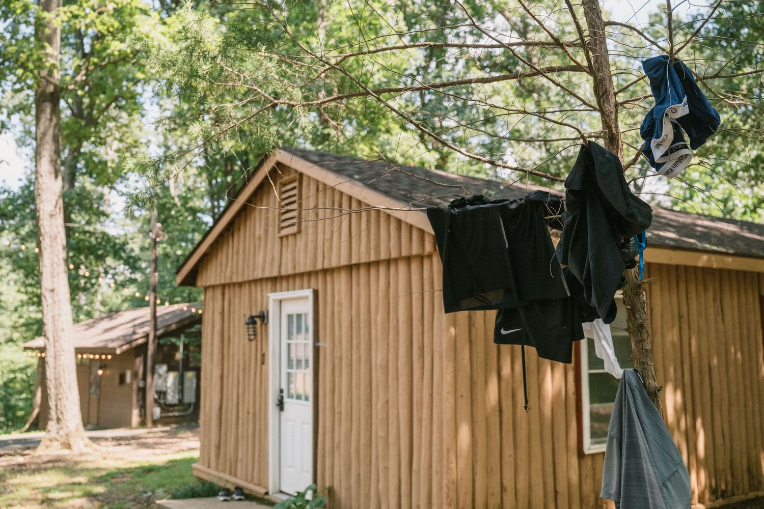 clothes hang outside of summer camp cabins at wedding