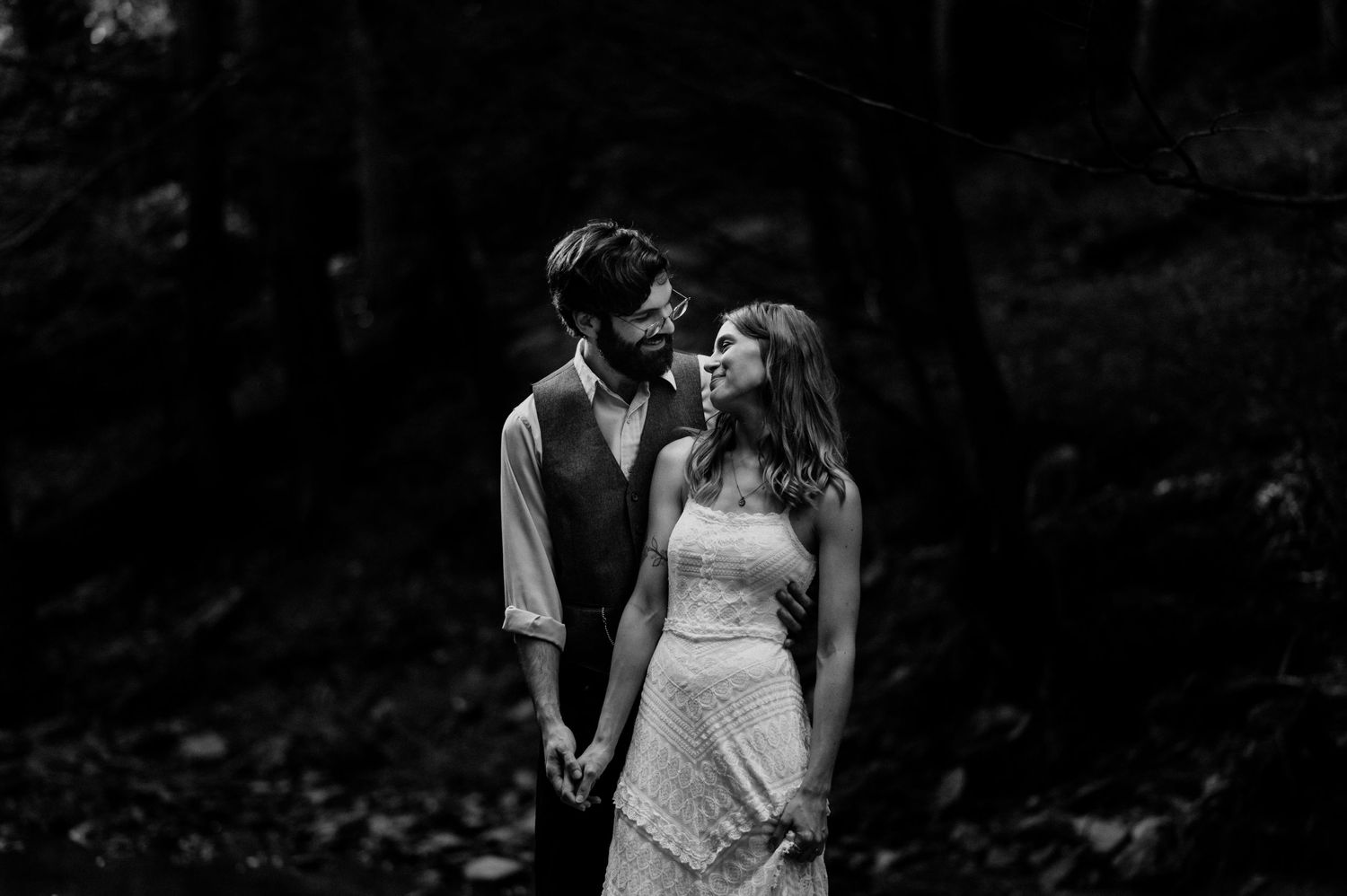Intimate black and white portrait in mystical forest setting.
