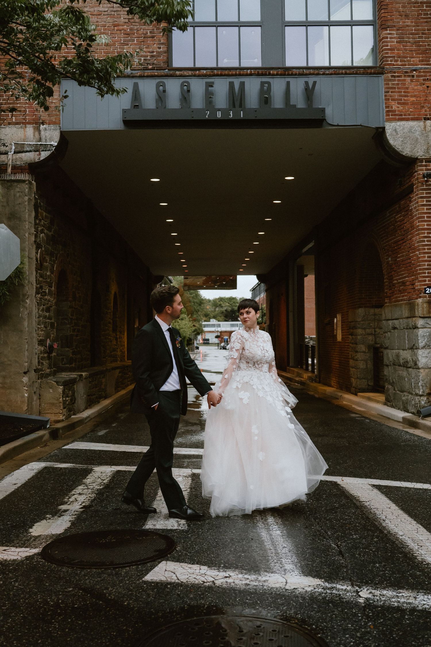 A couple walks through an industrial tunnel marked 'DUFFMALL' during their wedding photoshoot.