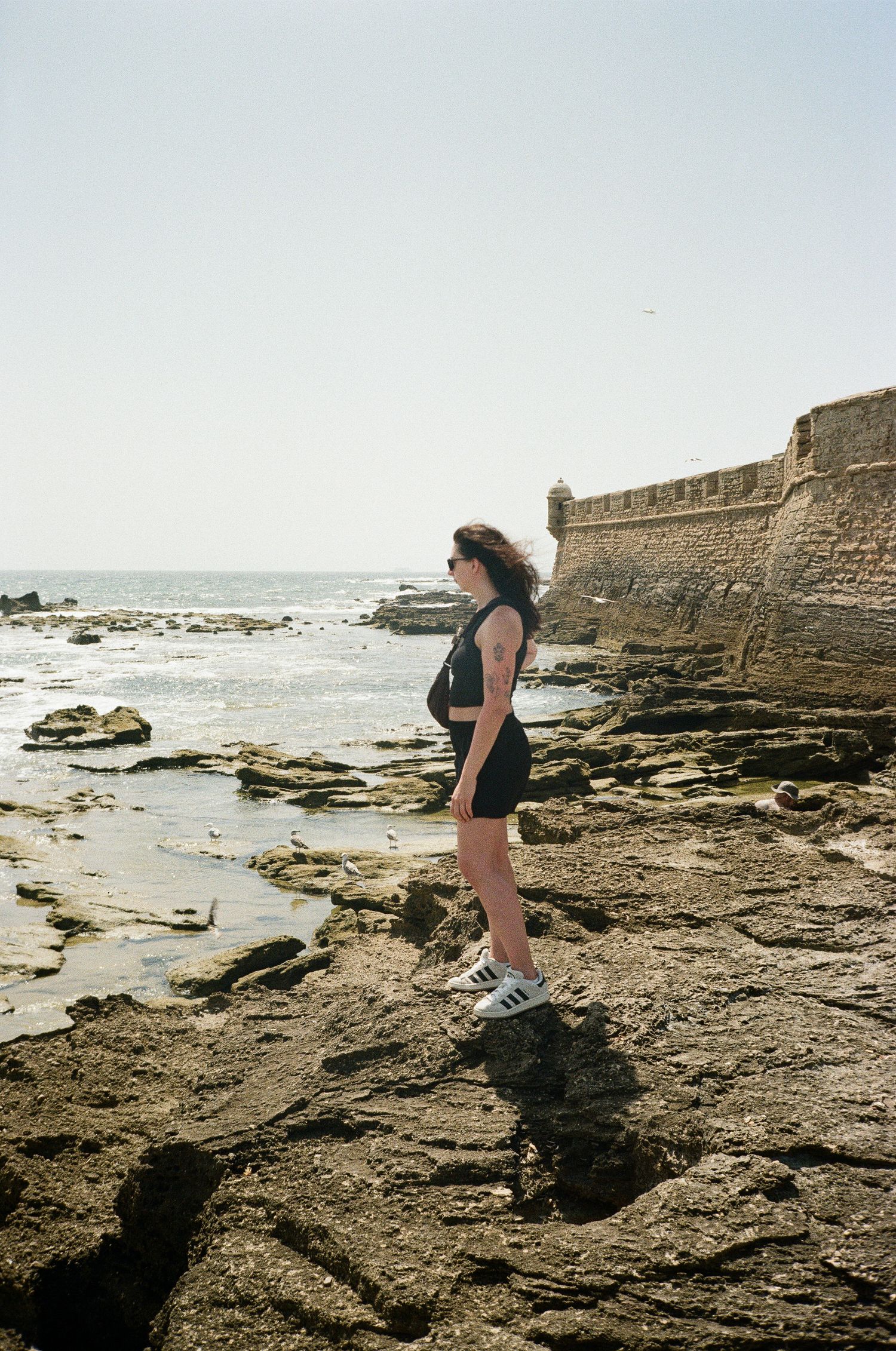Rocky coastal terrain with historic fortress walls overlooking the ocean.