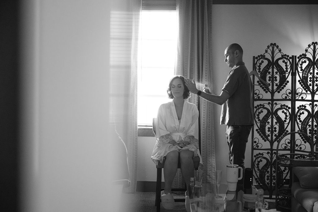 A series of black and white photos showing people getting ready in a room with natural light streaming through windows.
